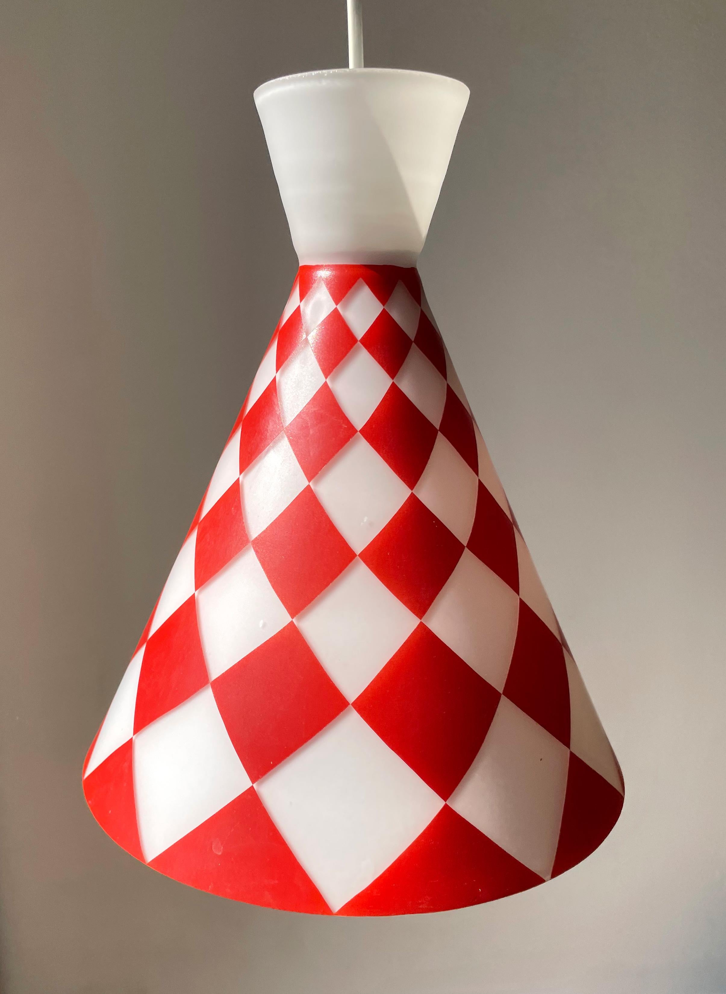 Midcentury European modern cone shaped white opaline glass pendant with bright red rhombus shaped decorations and milky white top. Original plastic canopy. Manufactured in the 1970s. Great vintage condition consistent with age and wear. Local