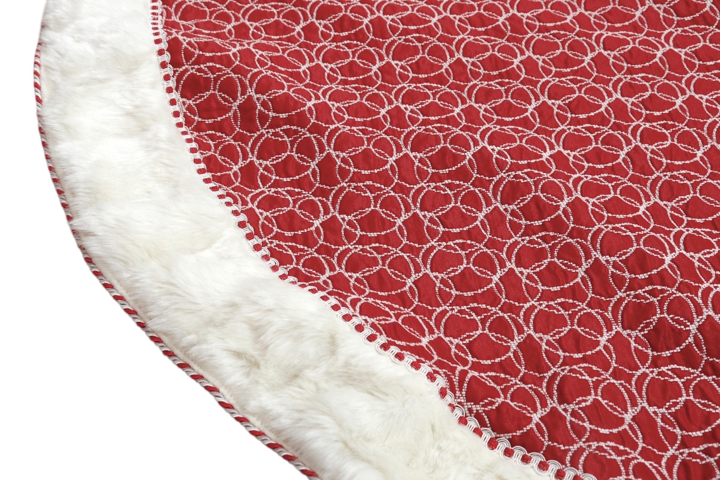 A festive quilted Christmas tree skirt in red and white. A bright red brocade is decorated with overlapping circles reminiscent of Christmas baubles. Around the edge a white faux fur trim is framed with a red and white scroll braided gimp, and