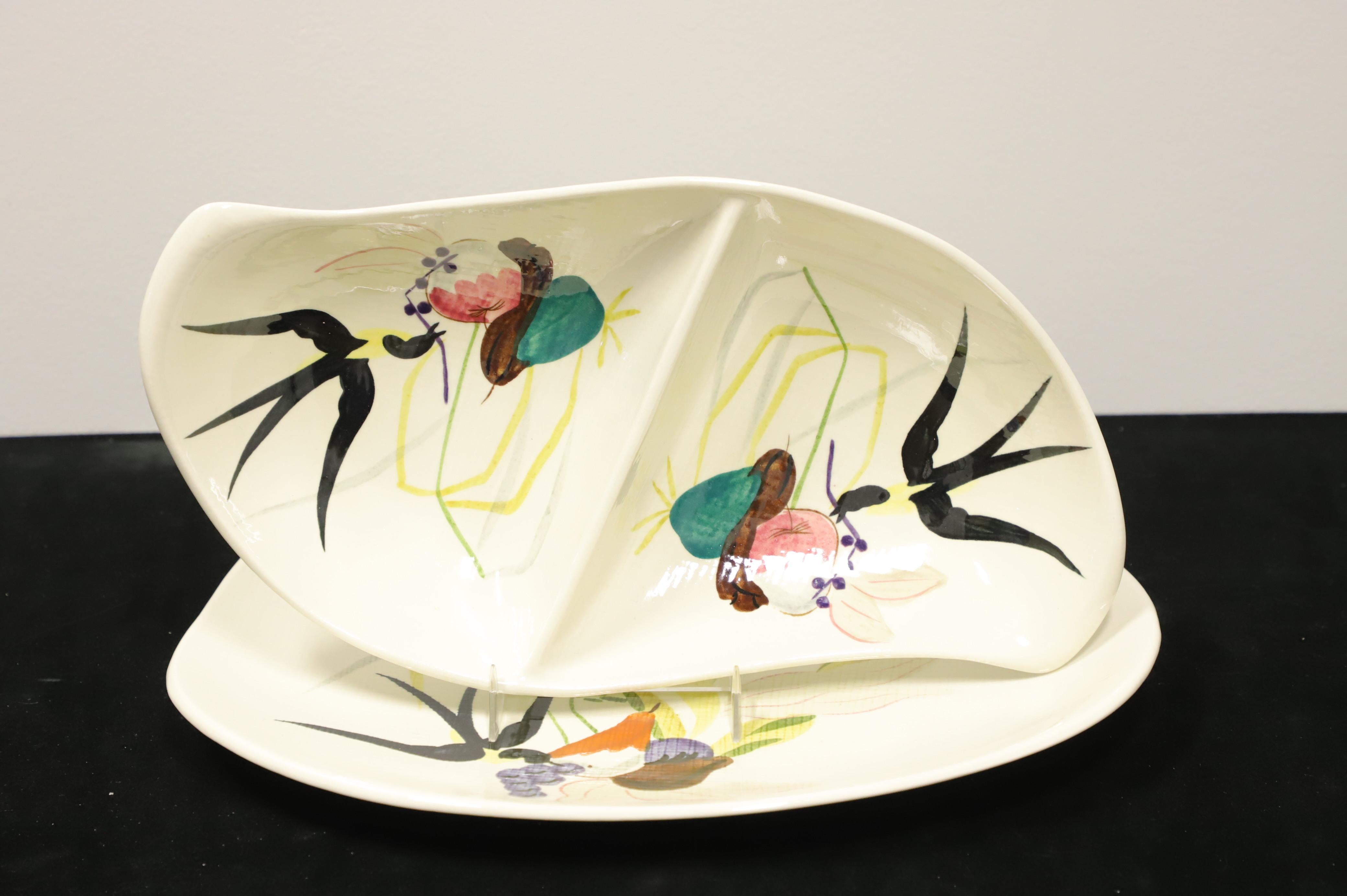 A Mid 20th Century divided vegetable bowl and platter by Red Wing, in their Capistrano pattern. Both pieces have a unique curved shape and are hand painted depicting the swallows returning to that bountiful area of California. Platter is ovenproof.