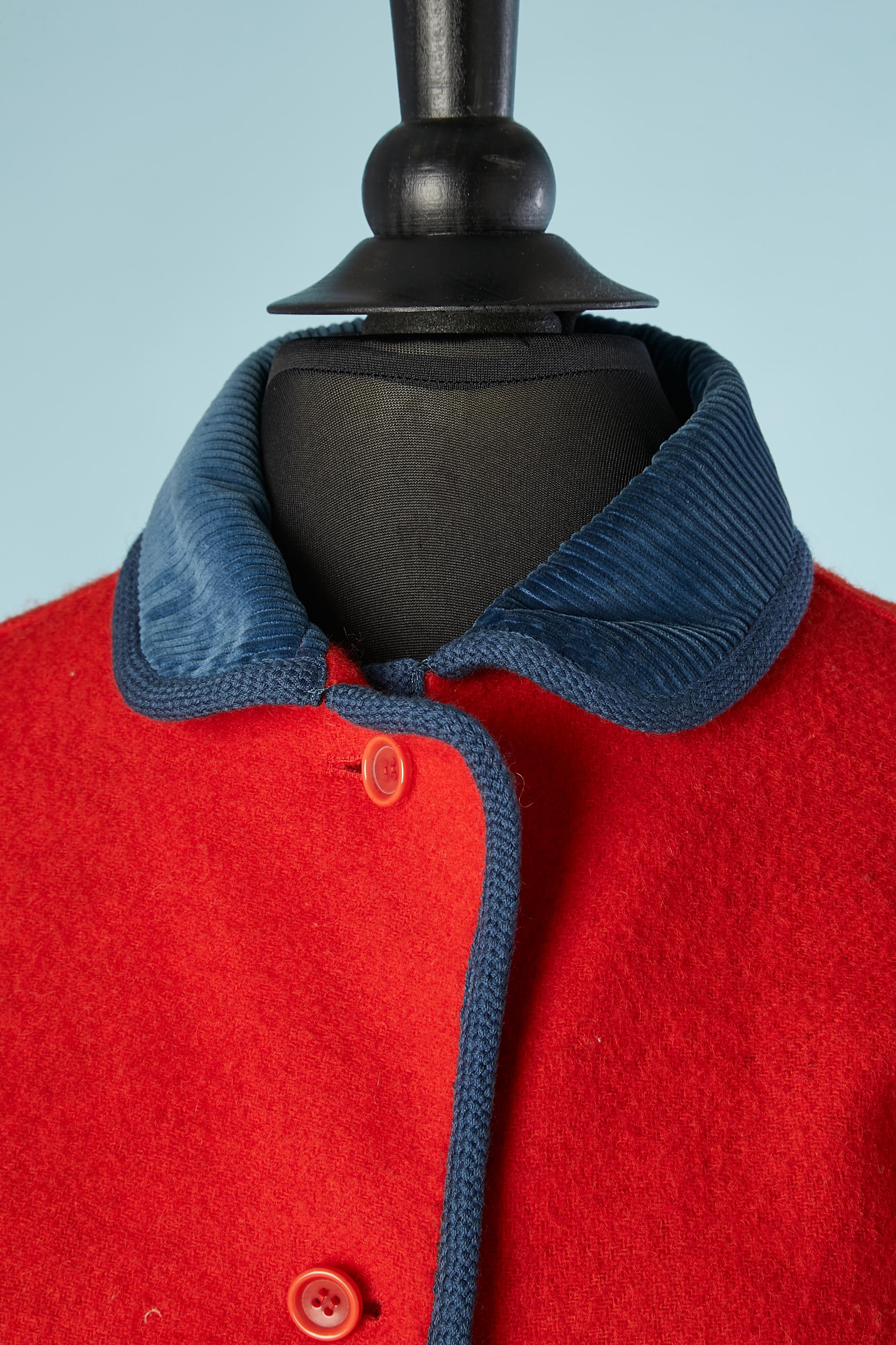 Jupette en laine rouge avec col en velours côtelé bleu. Tresse de laine bleue sur le bord. Composition de la doublure : acétate. Pad d'épaule. Demi-courroie dans le dos 
NOTE/ la jupe a été tournée du mauvais côté, les fentes de la jupe sont sur le