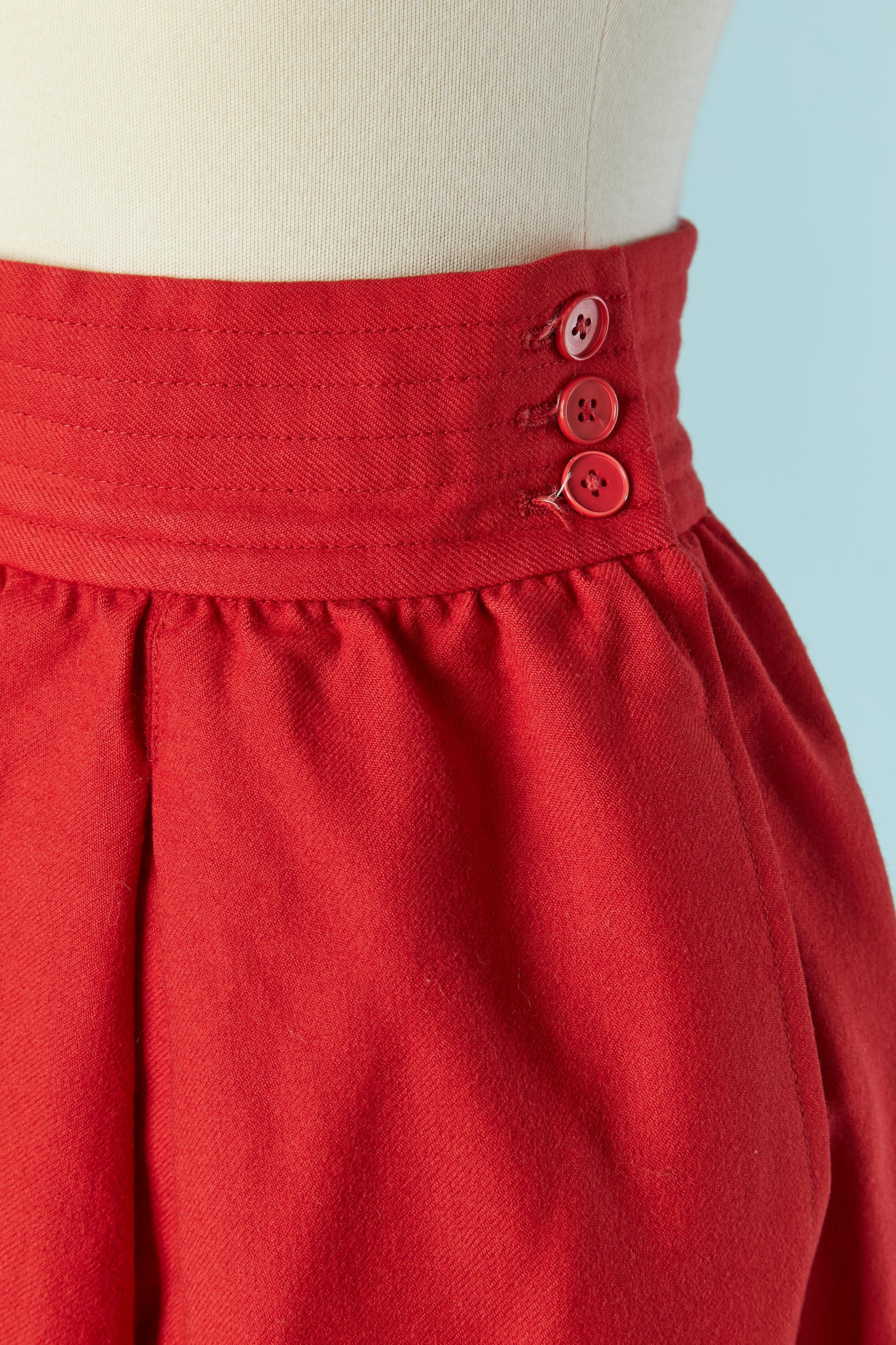 Gonna in lana rossa con tasca su entrambi i lati e vita impunturata. Chiusura con bottoni e asole sul lato sinistro + zip. 
Fodera in rayon all'interno delle tasche
TAGLIA 34 / XS 