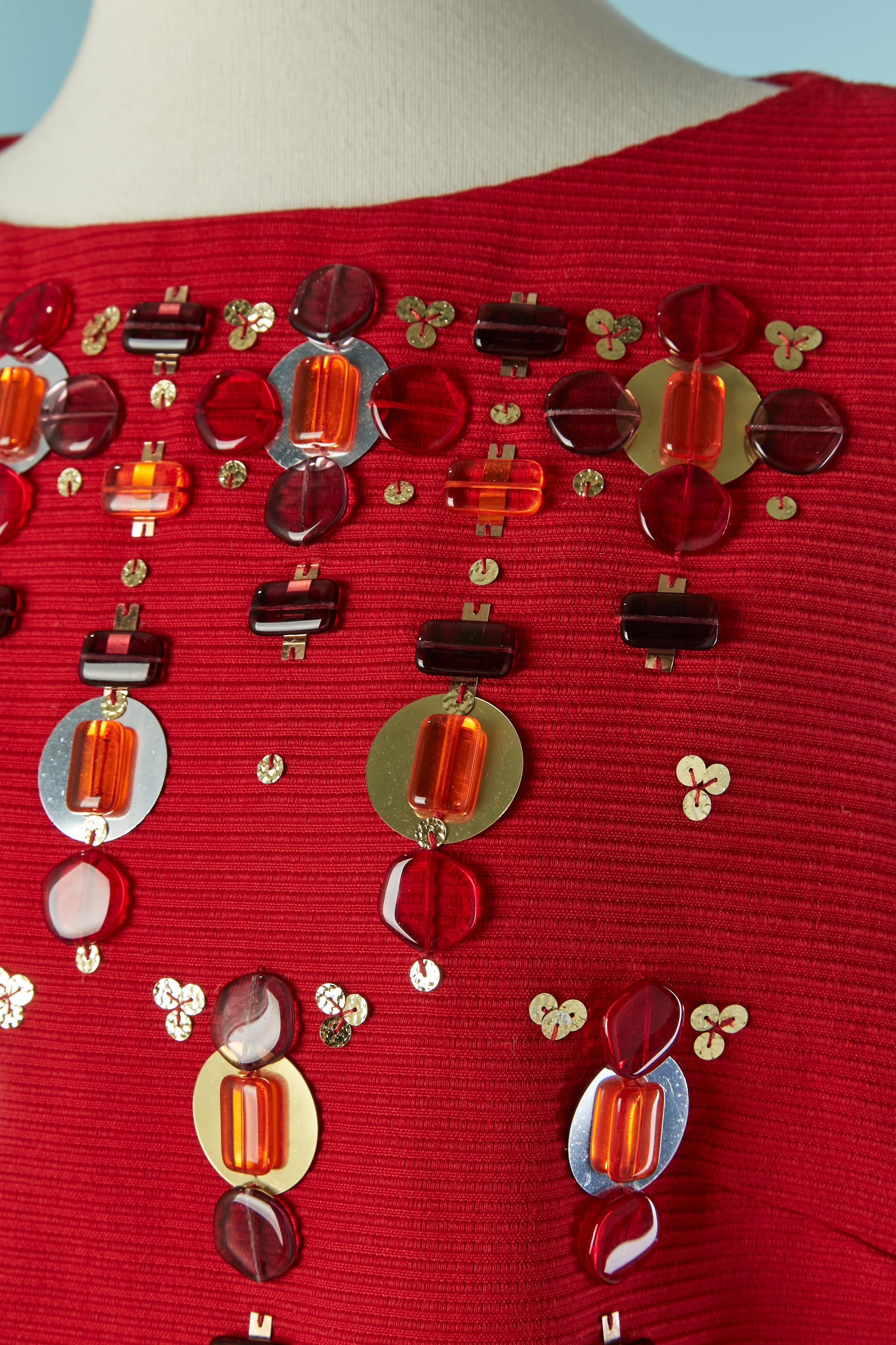 Rotes ärmelloses Cocktailkleid aus Wolle mit Verzierungen . Seidenfutter. Zusammensetzung der Stickerei: Glas, Kunststoff und PVC 
Reißverschluss und Haken-Ösen-Verschluss in der hinteren Mitte. 
GRÖSSE 42 (Fr) 10 (US) 