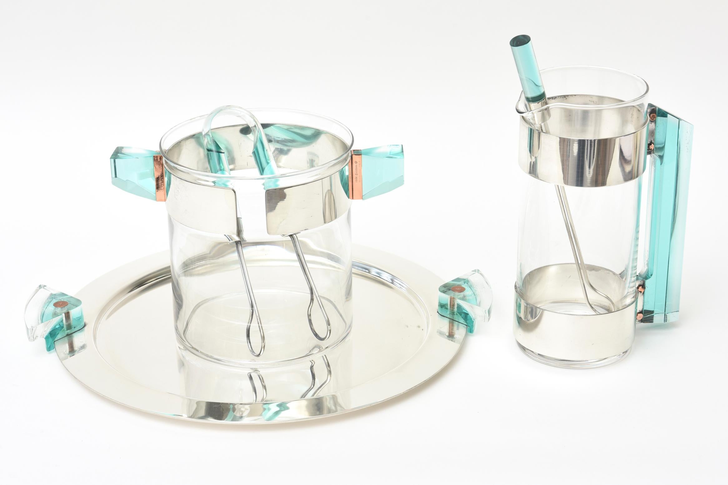These amazing luscious set of hallmarked Italian Rede Guzzini barware set is comprised of a round silver plate tray with Lucite handles with copper accents, an ice bucket, a martini shaker, ice thongs and the stirrer for the martini shaker. There