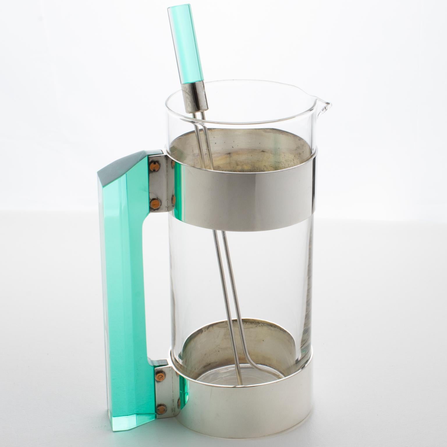 Italian Rede Guzzini designed this stylish barware set in the 1970s. This set includes a Martini cocktail pitcher and its pairing stirrer stick. The molded glass container has a silver plate and copper metal framing complimented with an incredible