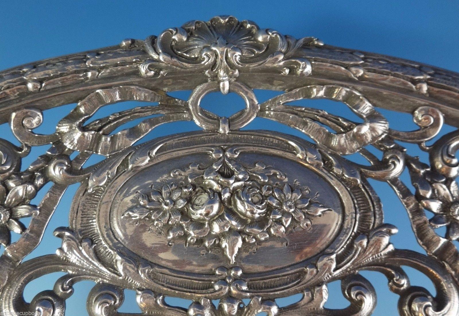 Redlich & Co
Very finely made sterling silver centerpiece bowl made by Redlich & Co, circa 1920-1930s. It features a 4 wide floral ribbon and medallion pierced design. It is monogrammed in the center and hallmarked with #8388. It measures 2 1/2 x 18