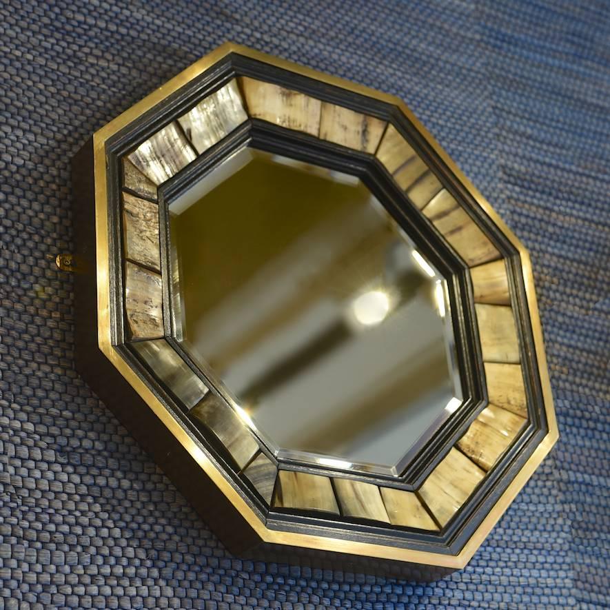 Octagonal brass framed bevelled glass mirror with inset horn and ebonised wood surround, by Antony Redmile, circa 1970. Another is available in a darker colour.

Selling from his shop at 73 Pimlico Road in the 1960s-1970s, designer J. Antony Redmile