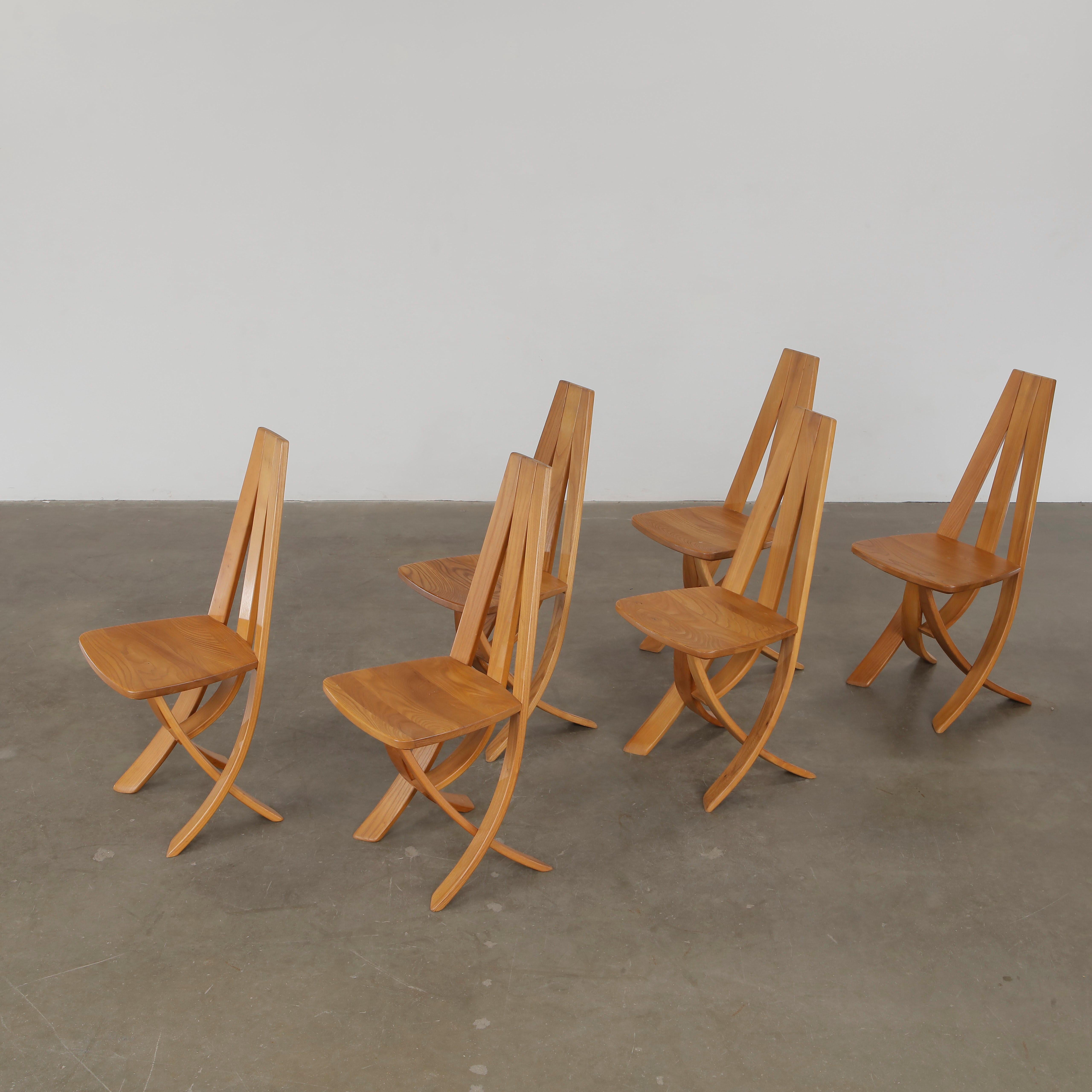 Sculptural wood chairs with high curved backs. Iconic French design. 

Height: 39.2 in. Width: 16.5 in. Depth: 18 in. Seat Depth: 15.5 in Seat Height: 18.5 in.