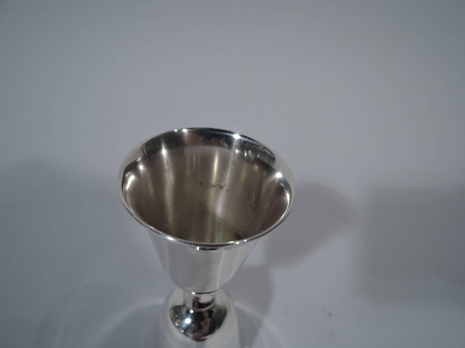 Mid-Century Modern sterling silver double jigger. Made by Reed & Barton in Taunton, Mass., in 1956. One large and one small bell-form bowl joined back-to-back with short twisted stem. Hallmark includes date symbol and no. X755. Weight: 3 troy ounces.
