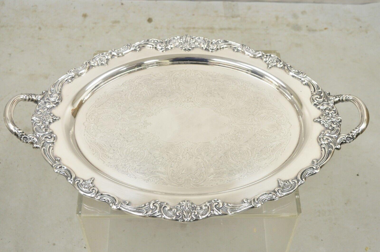 Vintage Reed & Barton 1955 25 Silver Plated Oval Twin Handle Large Serving Platter Tray. Item features heavy Construction, Ornate Floral Design Handles, Etched Center, Original Hallmark, Quality Craftsmanship, Large Impressive Size.
Circa Mid 20th
