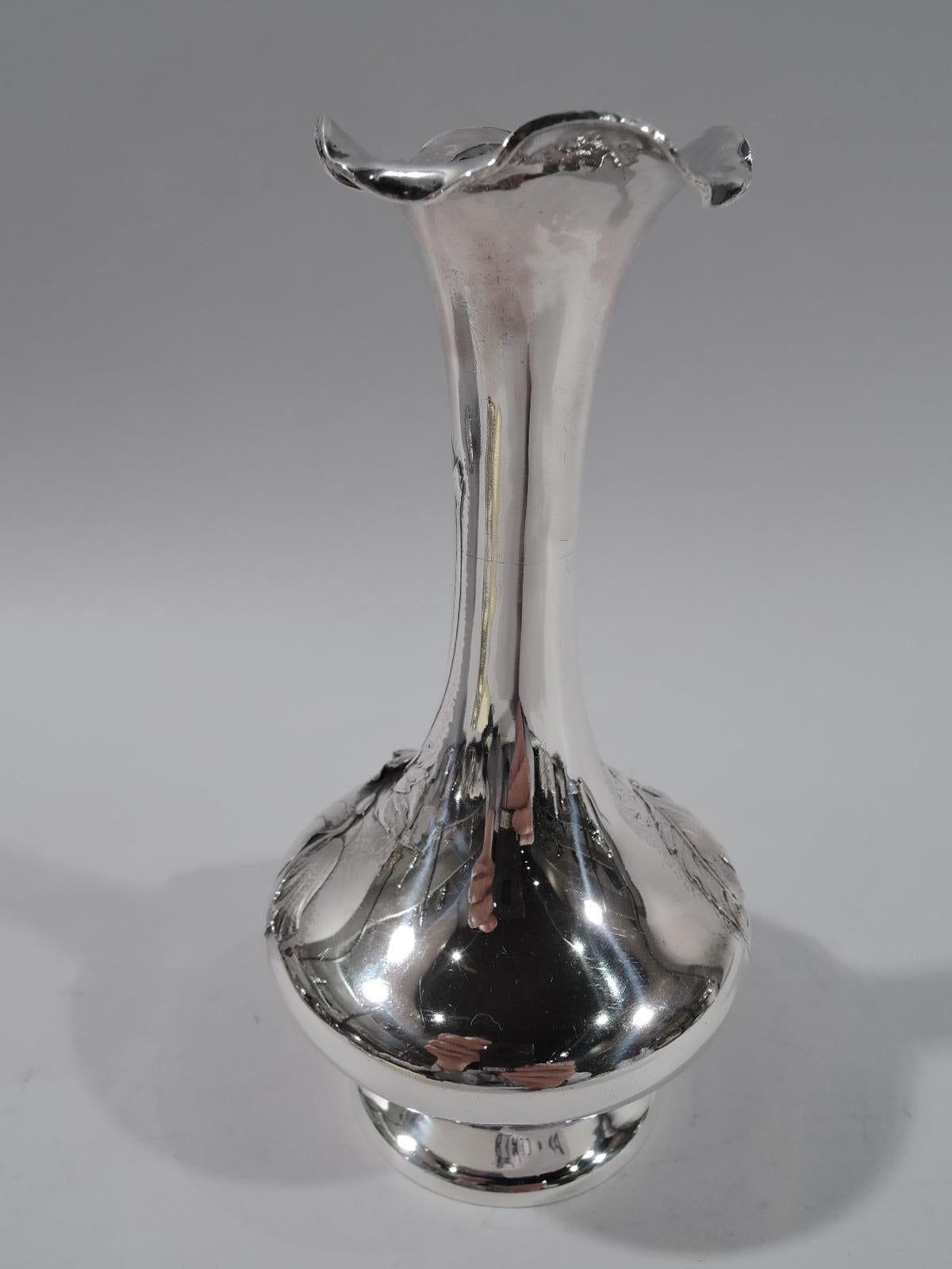 Aesthetic sterling silver bud vase. Made by Reed & Barton in Taunton, Mass., circa 1890. Bellied bowl on raised and inset foot; tall cylindrical neck with wavy petal rim. Chased floral ornament with blooms and leaves overlapping and winding up neck.