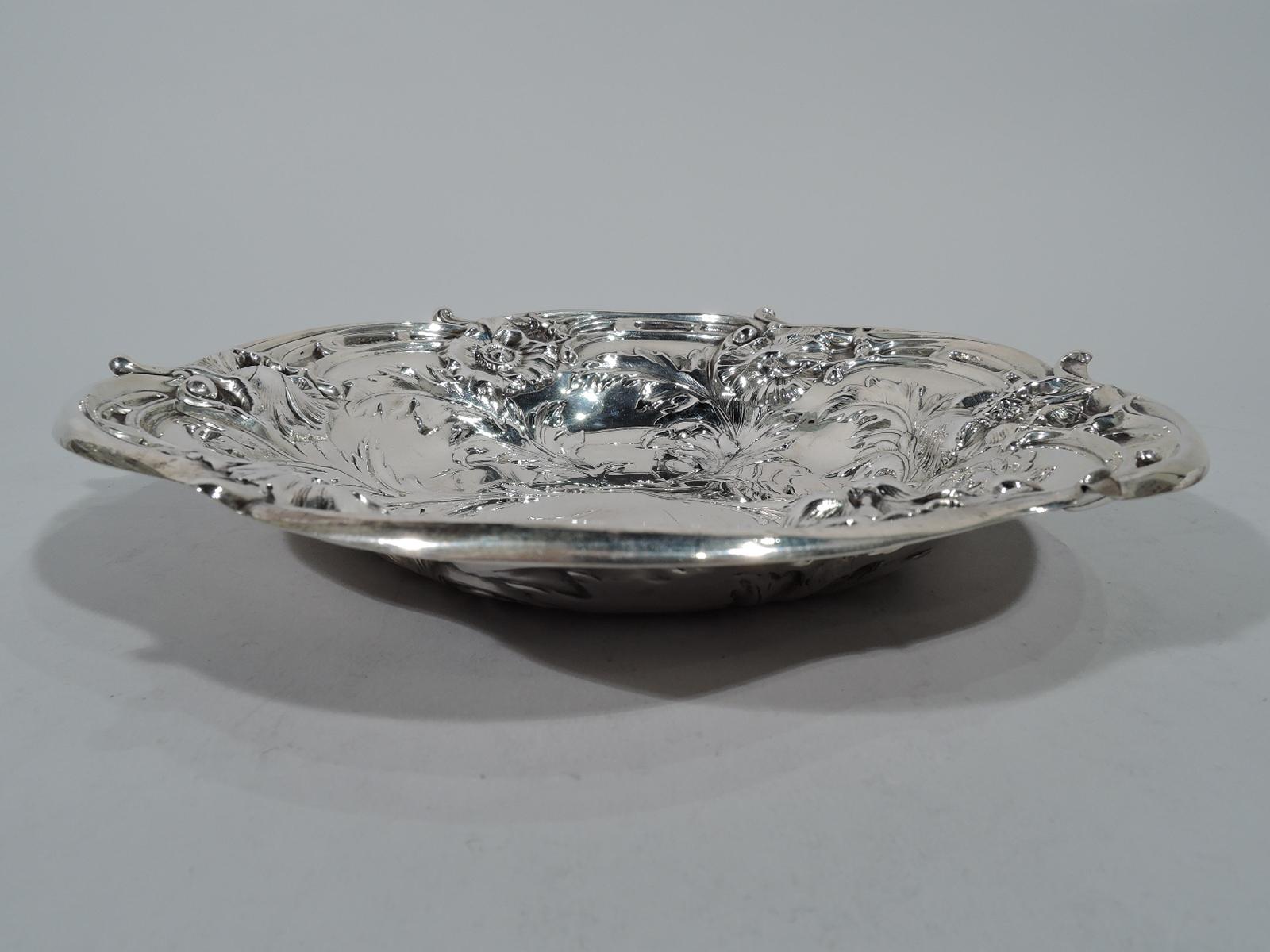Art Nouveau sterling silver bowl. Made by Reed & Barton in Taunton, Mass in 1956. Lobed well and scrolled rim. Chased ornament in form of flowers with stems terminating in well to make room for a frame (vacant). Tactile and dynamic. Hallmark