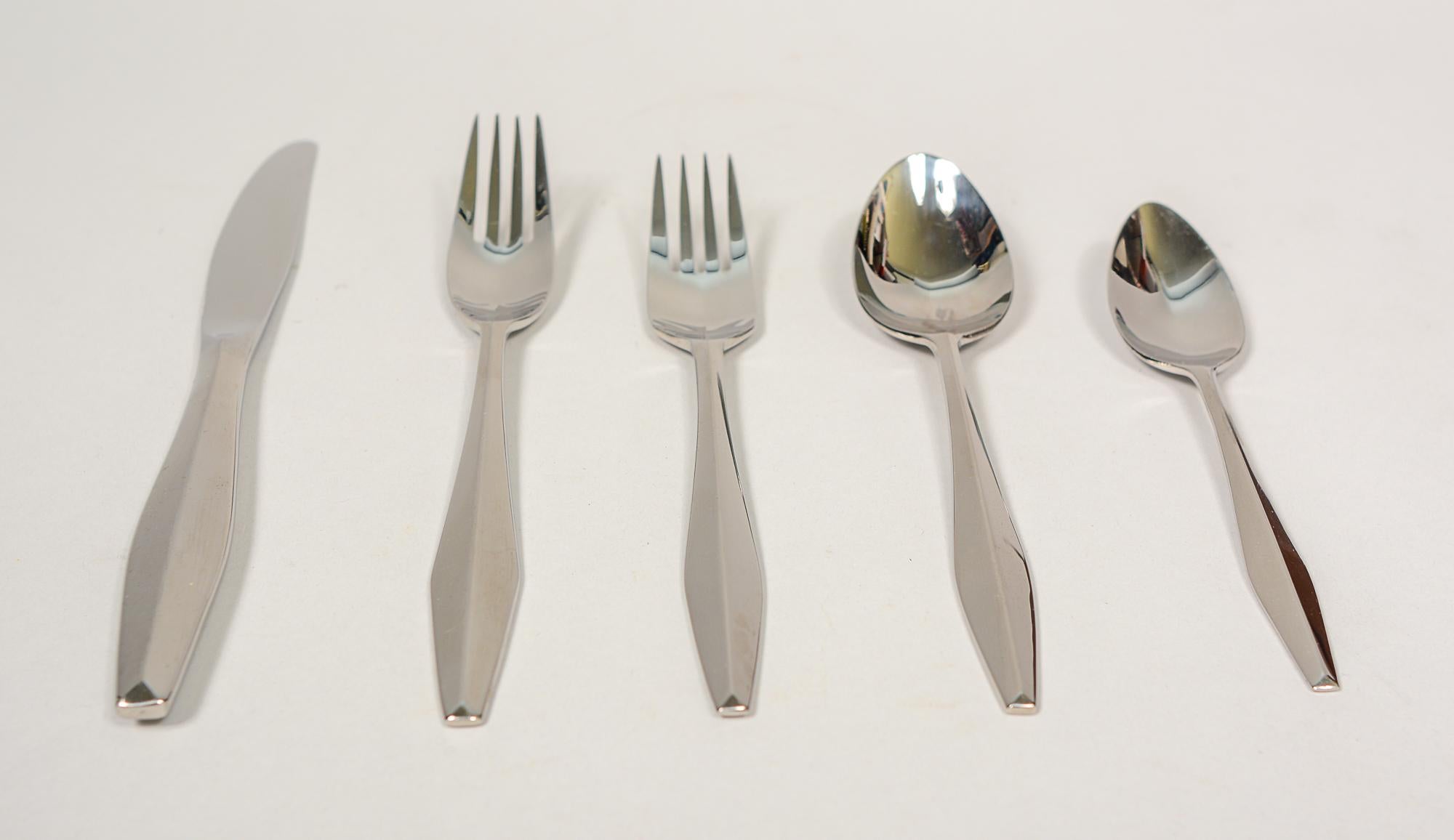 Diamante stainless steel flatware set by Reed & Barton. This set is service for eight with ten serving pieces. This pattern is the stainless version of the Diamond sterling pattern designed by Gio Ponti for Reed & Barton. This set shows light signs