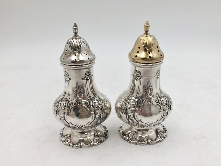 Reed & Barton pair of salt and pepper shakers in renowned Francis I pattern with exquisite fruit and floral motifs in Art Nouveau Style (one shaker with a gilt top), measuring 4 2/3'' in height by 2 1/3'' in depth by 1 3/4'' in width. Each bears