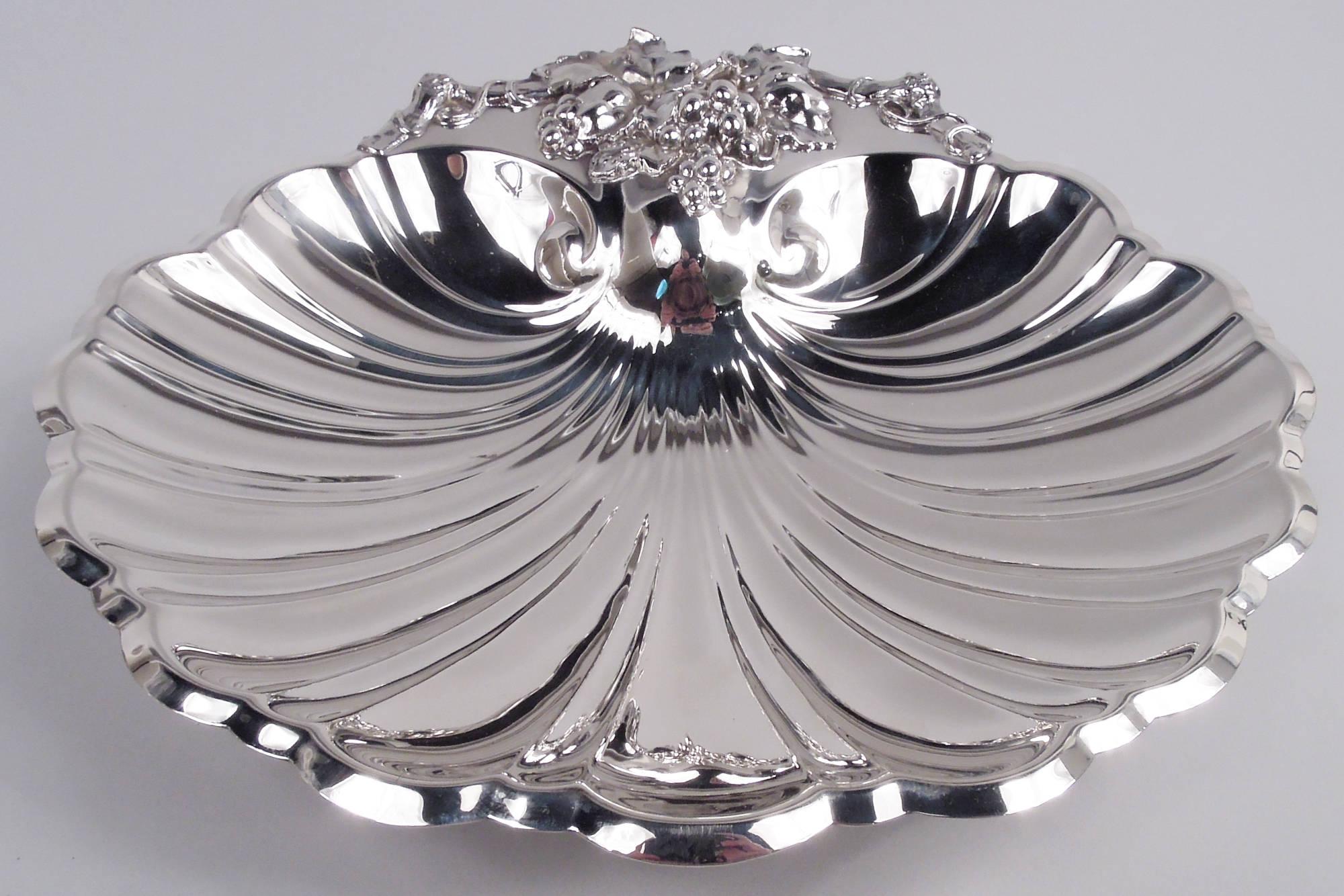 Modern Classical sterling silver scallop shell. Made by Reed & Barton in Taunton, Mass. in 1941. Tapering bowl with dynamic twisted flutes and scalloped rim. Valve rim is cast tendril-entwined fruiting grapevine. Three fruiting grapevine supports.