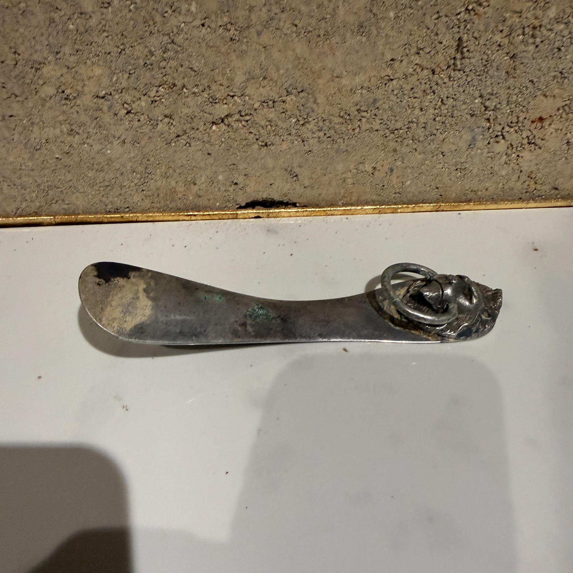 Pour votre considération, un cornet à chaussures vintage Reed & Barton en métal argenté. Période moderne du milieu du siècle. Fabriquée aux États-Unis. Patiné. Tête de lion. Il y a un anneau sur la tête du lion. Tampon au dos du