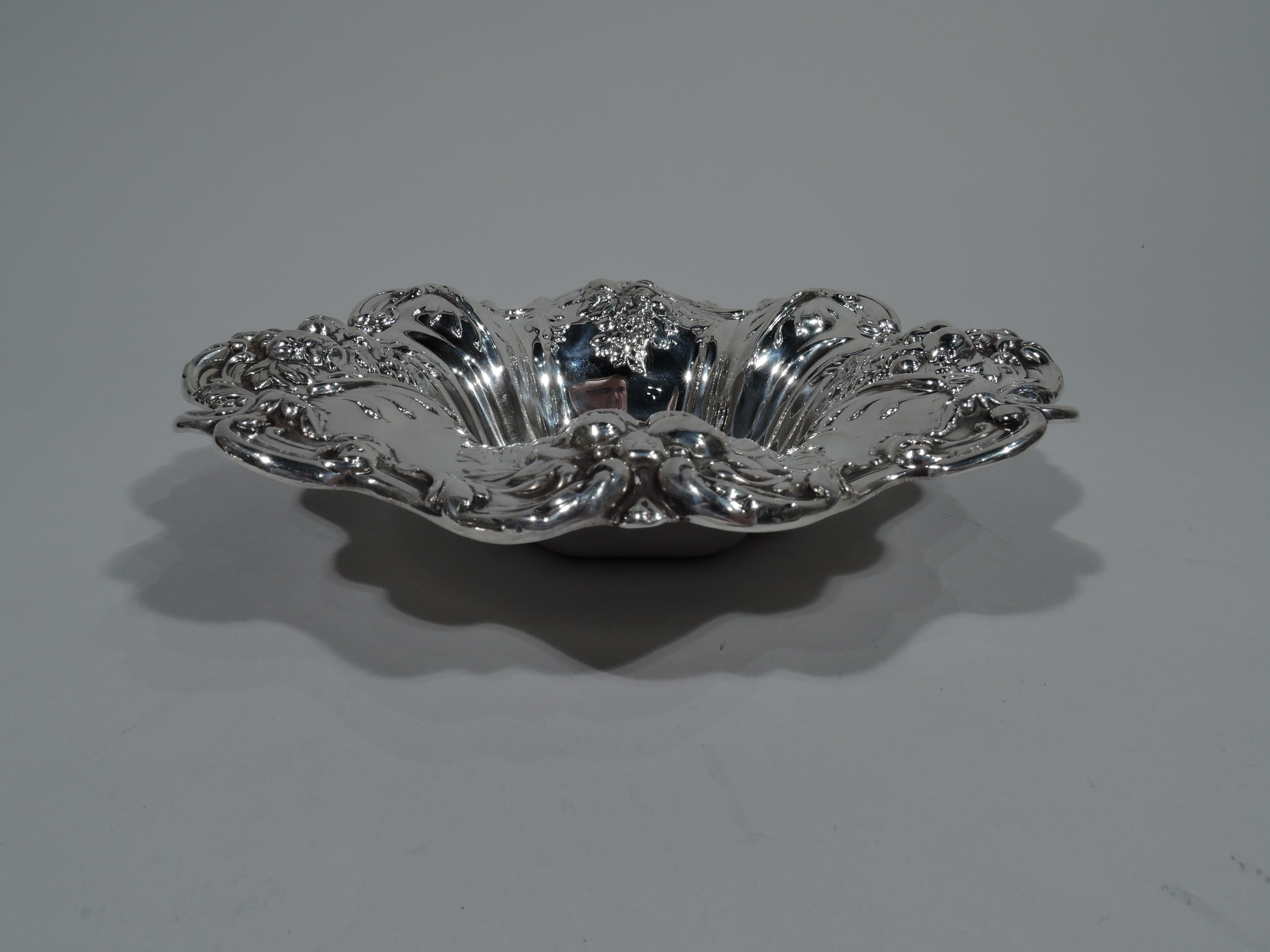 French Renaissance Revival sterling silver bowl in Francis I pattern. Made by Reed & Barton in Taunton, Mass. Quatrefoil well and wide flared mouth with wavy scrolled rim. Chased and embossed fruits. Hallmark includes pattern name and no. X569.