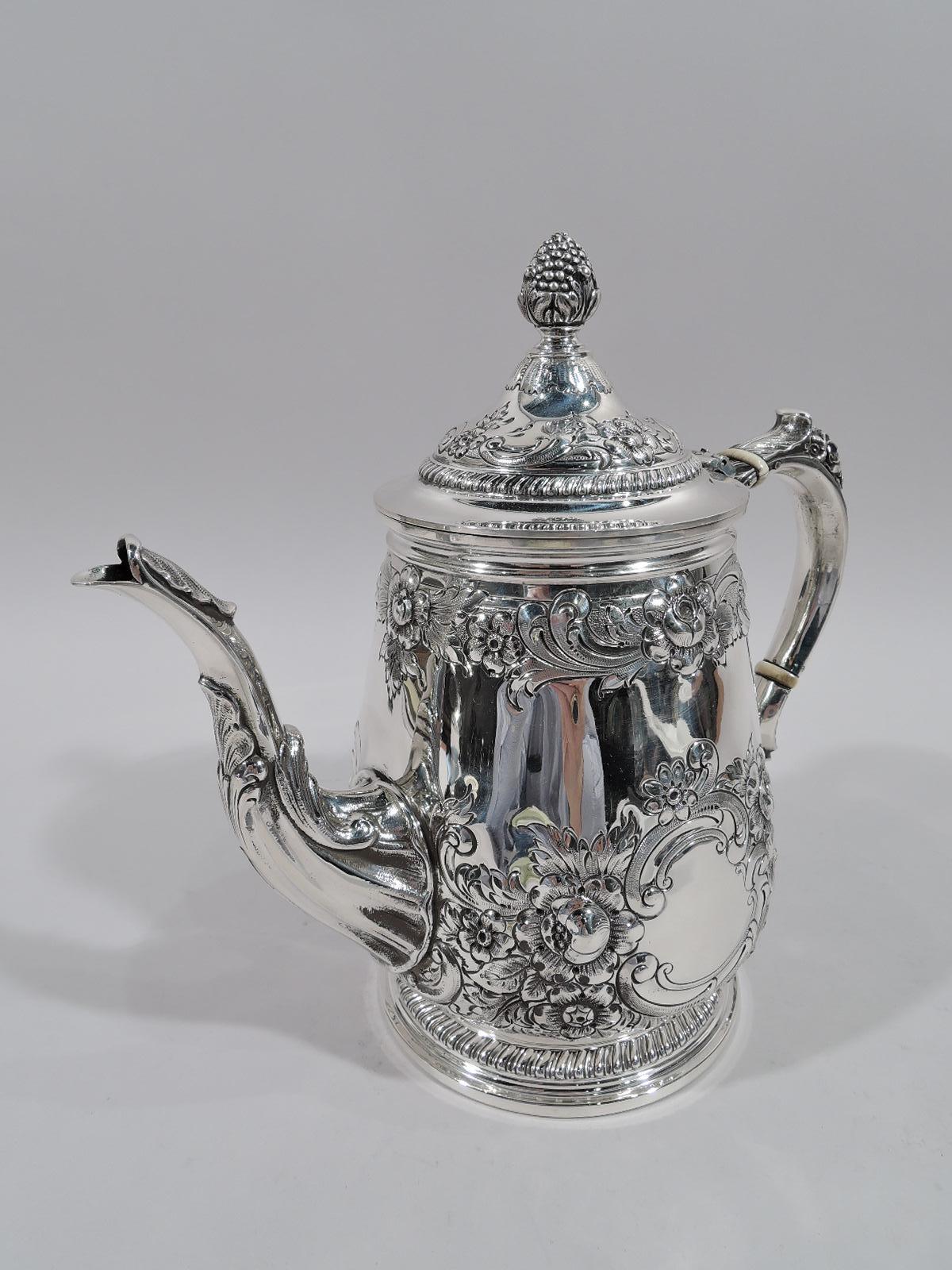 Pretty sterling silver coffeepot in Georgian pattern. Made by Reed & Barton in Taunton in 1937. Gently upward tapering with curved bottom and raised foot. Leaf-capped double-scroll handle and s-scroll pout. Cover hinged and domed with berry finial.