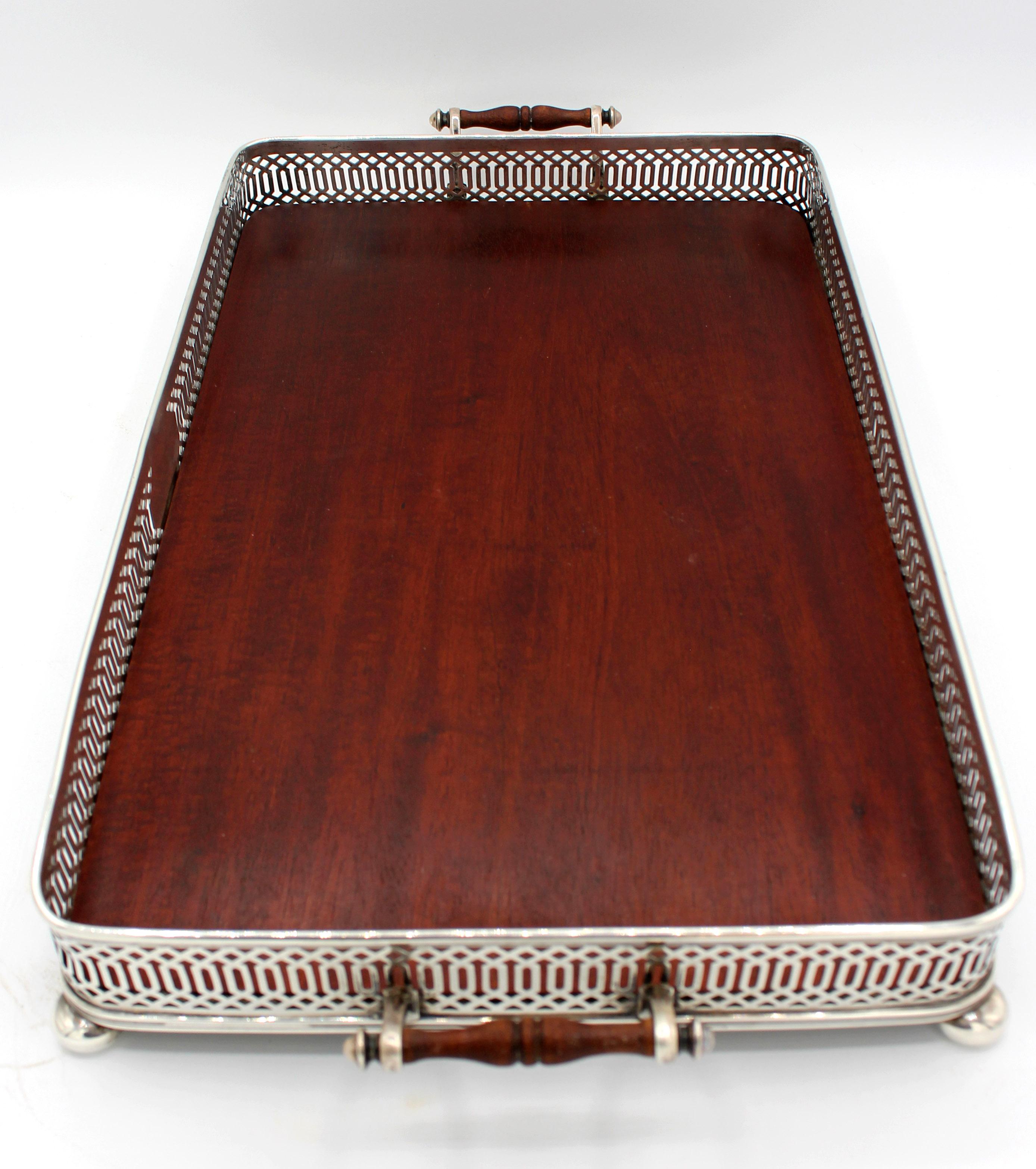 Reed & Barton sterling silver gallery tray raised on sterling button feet with wooden inset surface. Sterling & turned wood handles. Never engraved.
17.75
