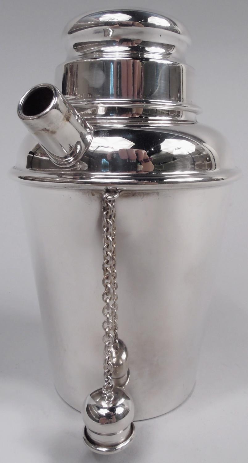 Midcentury Modern sterling silver mini martini shaker. Made by Reed & Barton in Taunton, Mass. in 1951. Straight and tapering sides, curved shoulder, and short neck. Snugly fitting bun cover and stubby spout with chained ball cap. All the essential