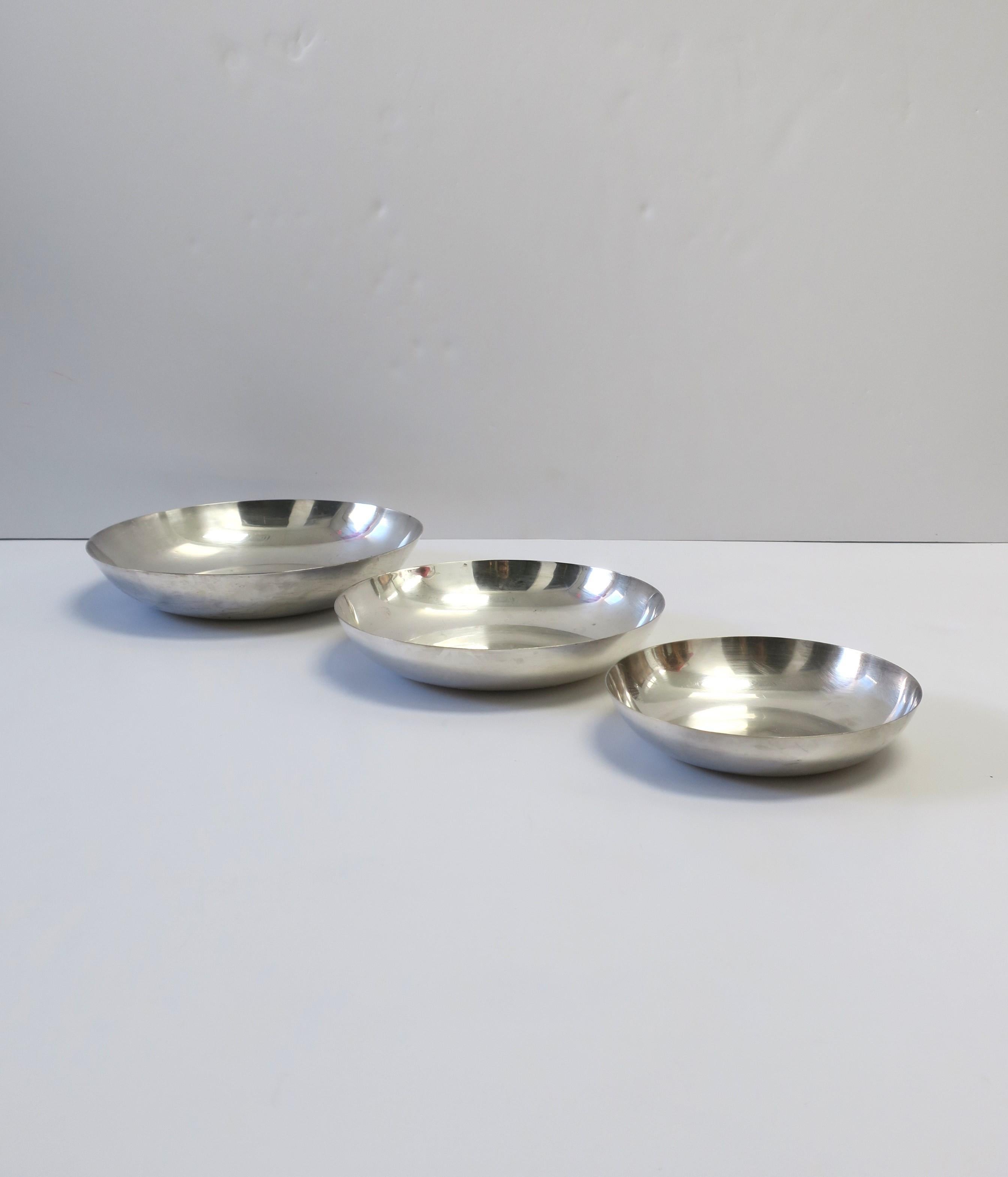 A set of three (3) graduated sterling silver plate over brass serving bowls in the Minimalist style, by Reed & Barton, circa late-20th century, USA. The sterling silver plate really make these bowls shine, a great set for entertaining on a table,