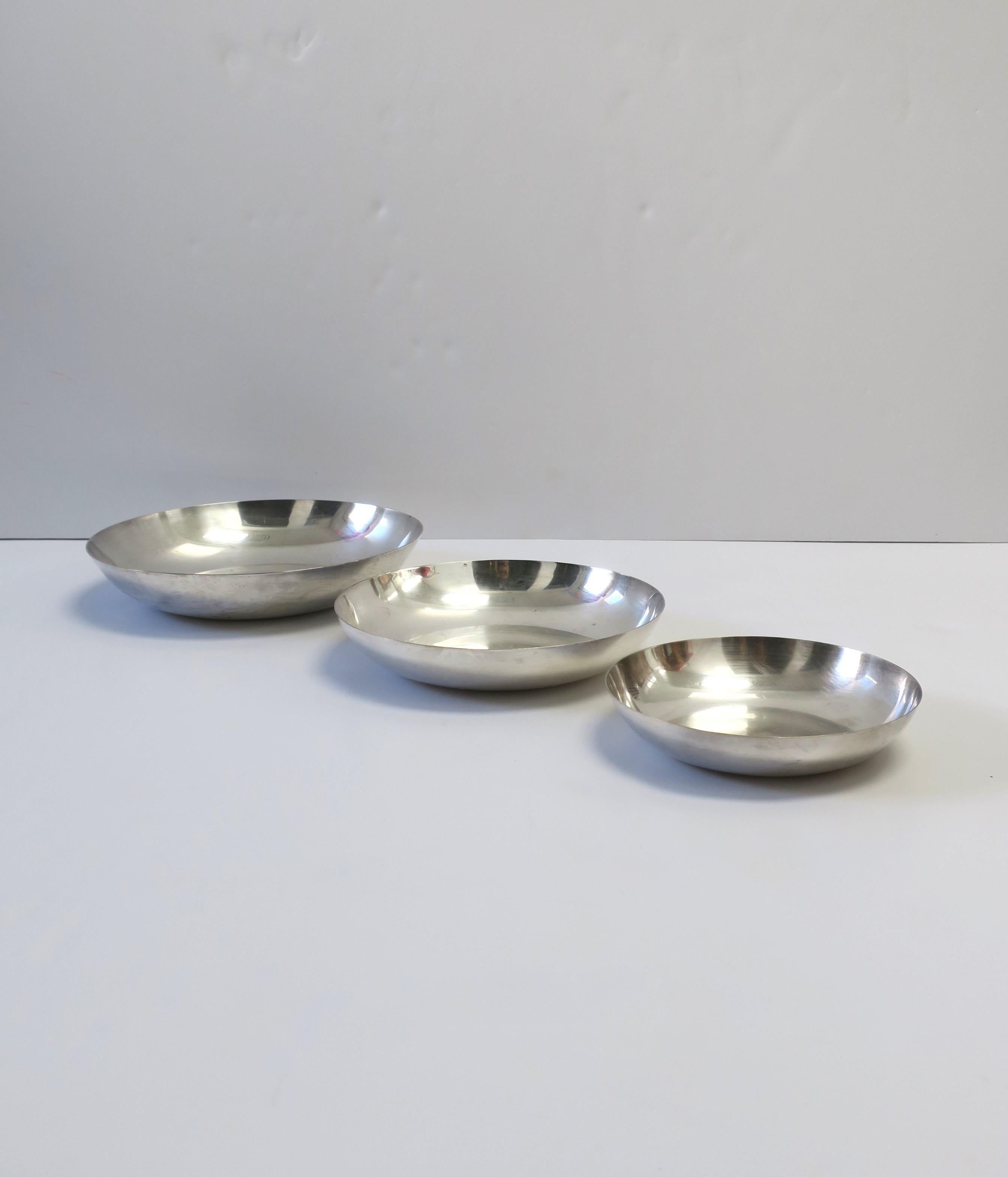 Un ensemble de trois (3) bols gradués en argent sterling et laiton de style minimaliste, par Reed & Barton, vers la fin du 20e siècle, USA. La plaque d'argent sterling fait briller ces bols, un ensemble idéal pour recevoir sur une table, un buffet,