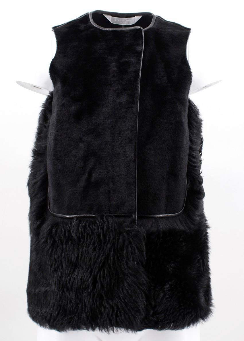 Reed Krakoff black button-down vest featuring the body in short fur while the bottom and sides are in shearling. Lining is in lamb skin and there are pockets on sides.

Fabrics: Shearling and Lamb Skin.

Size: XS, US 4, UK 8

Condition: