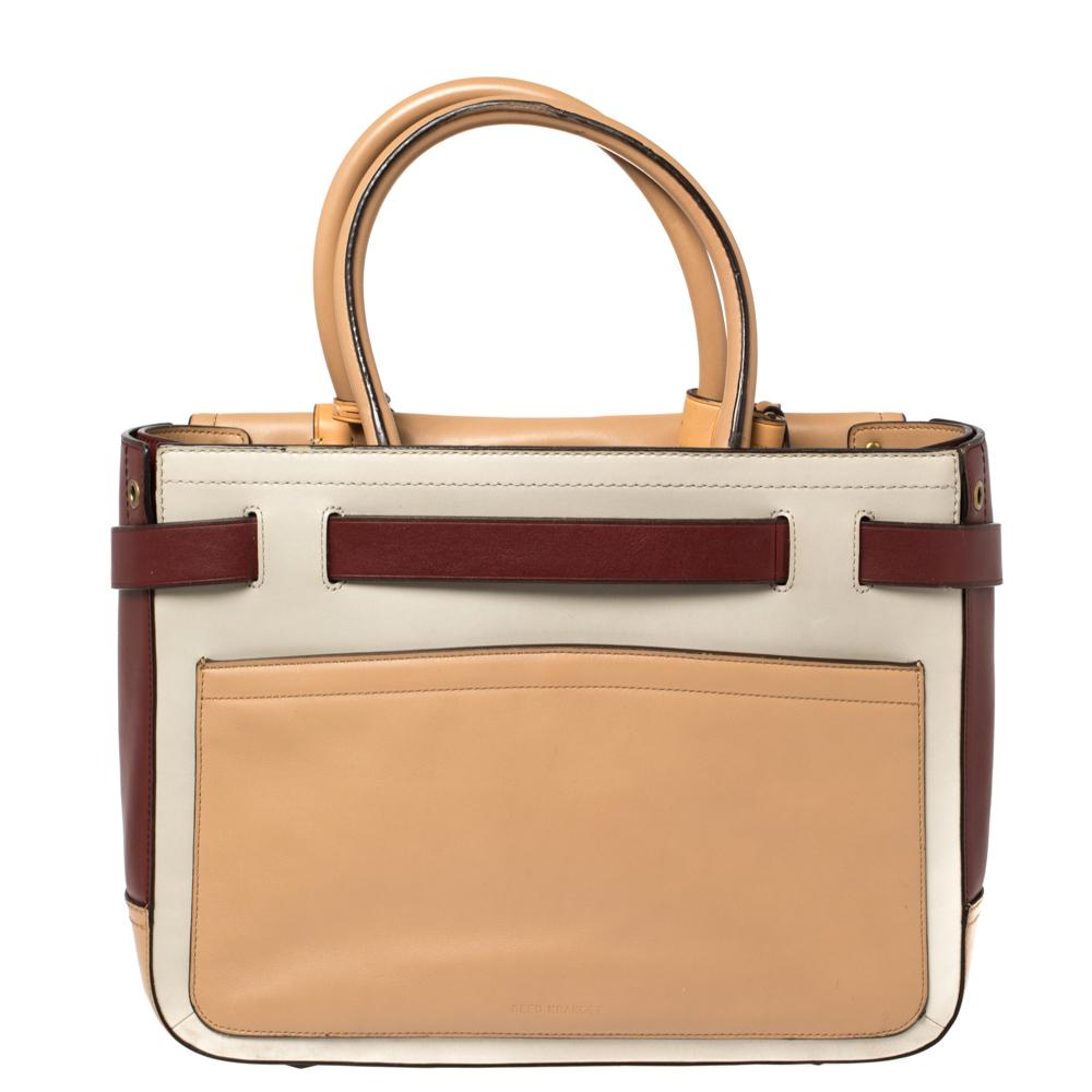 This Reed Krakoff Boxer tote features belt detailing at the front and is crafted from multicolor leather. It is equipped with dual-rolled handles, buckles, and a fabric-lined interior that has enough space to hold all your daily