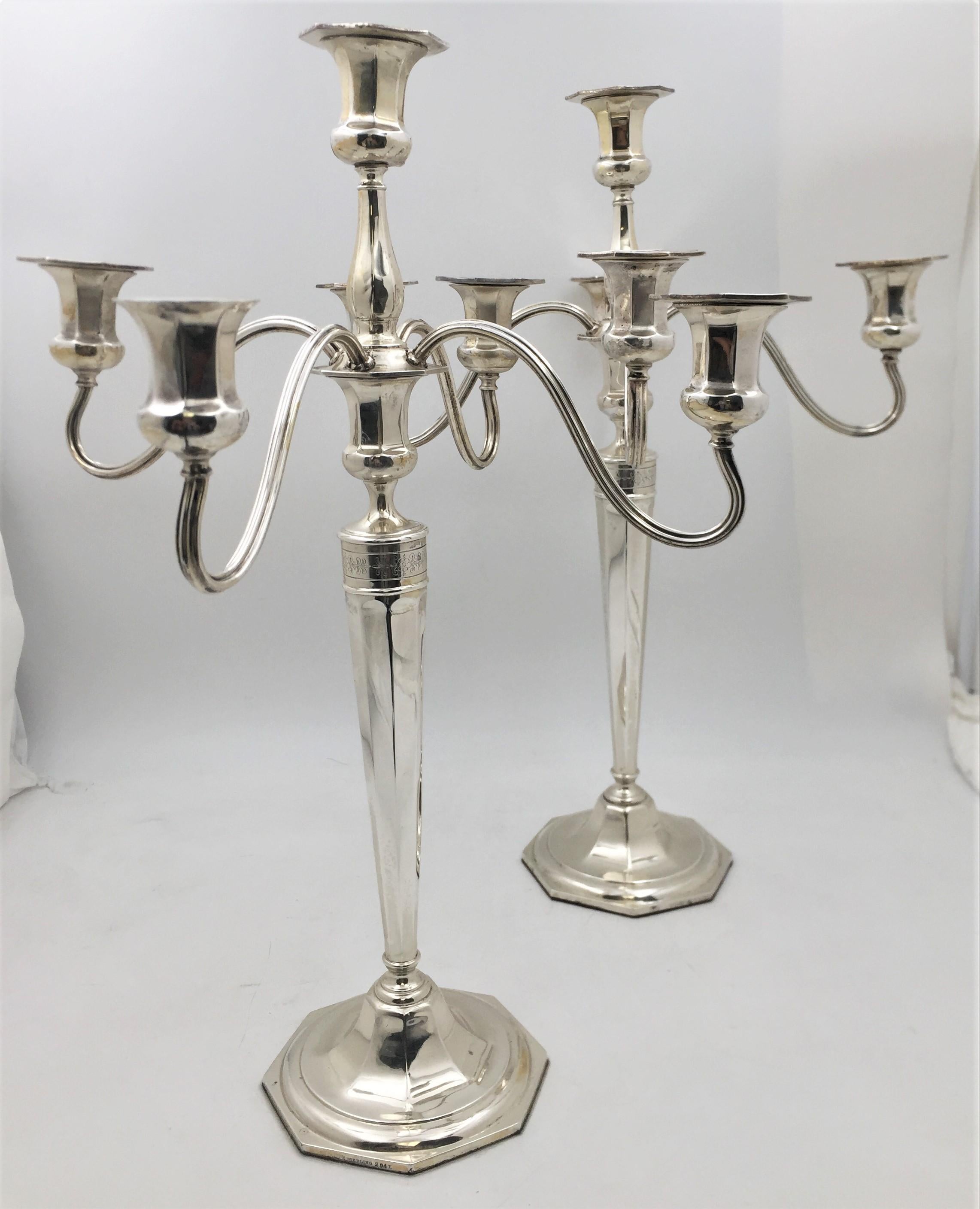 Pair of Reed & Barton sterling silver 5-light candelabra from 1907 in Hepplewhite pattern and in Art Deco style. Standing on octogonal bases, these candelabra typify the Art Deco style with their elegant proportions. An engraved floral frieze adorns