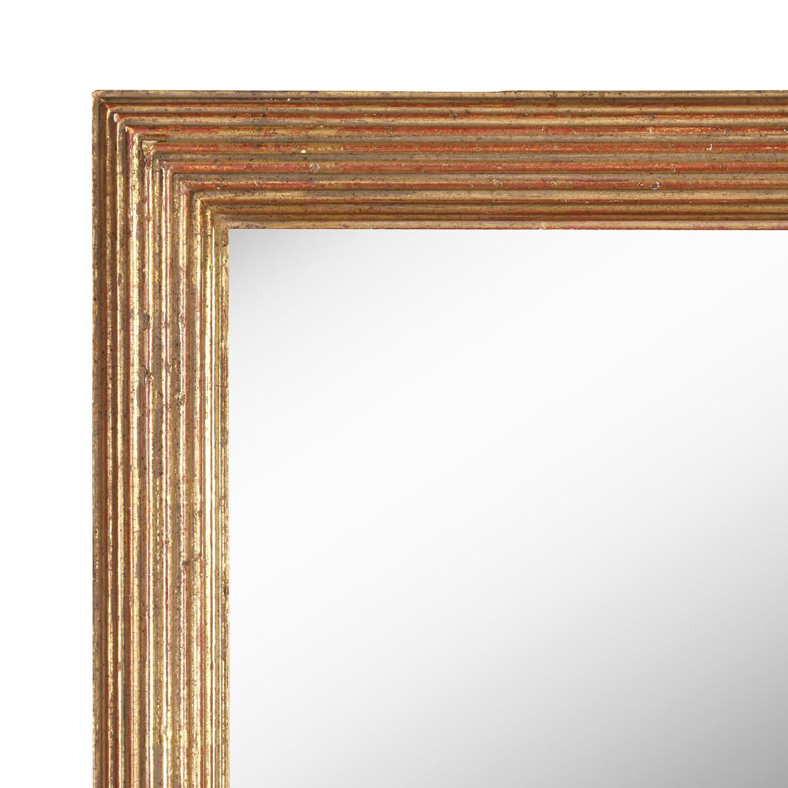 A reeded carved gilt rectangular wall mirror.  Natural patina to finish from wear and age add to the vintage beauty of the mirror with some chips and losses to the frame