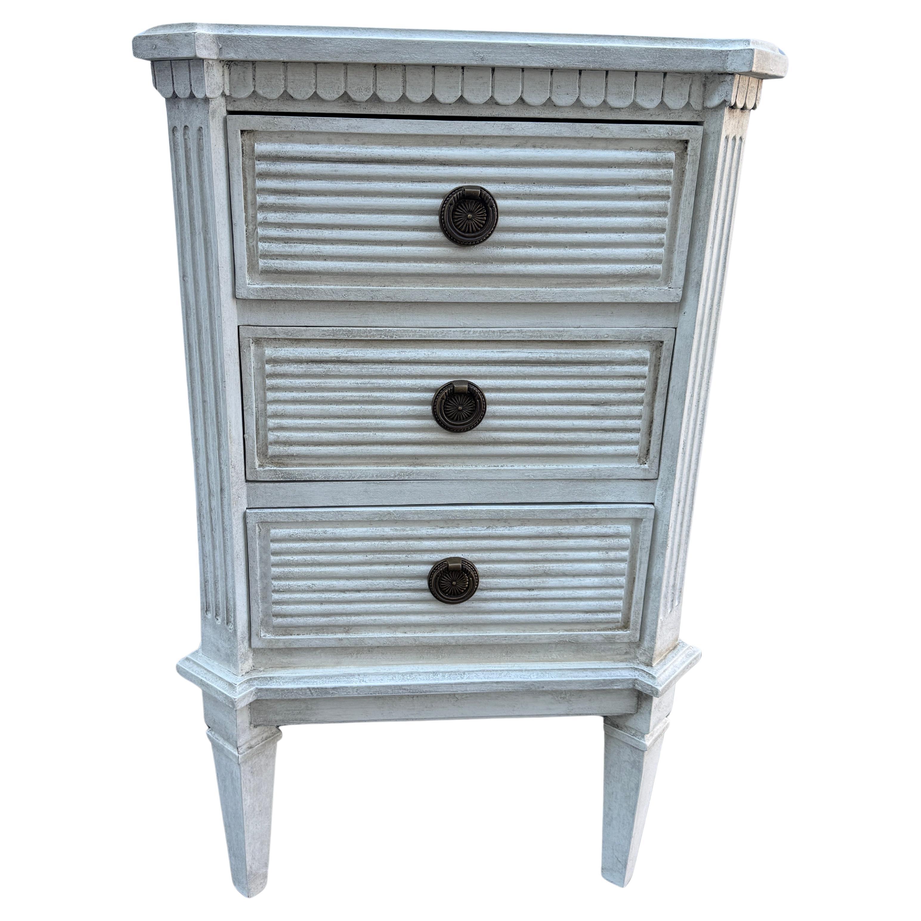 White Painted Gustavian Style Chest of Drawers

Hand painted Gustavian style chest with three drawers constructed from solid wood with a hand-applied distressed finish with brass ring hardware.  This classic Swedish style chest of drawers, small