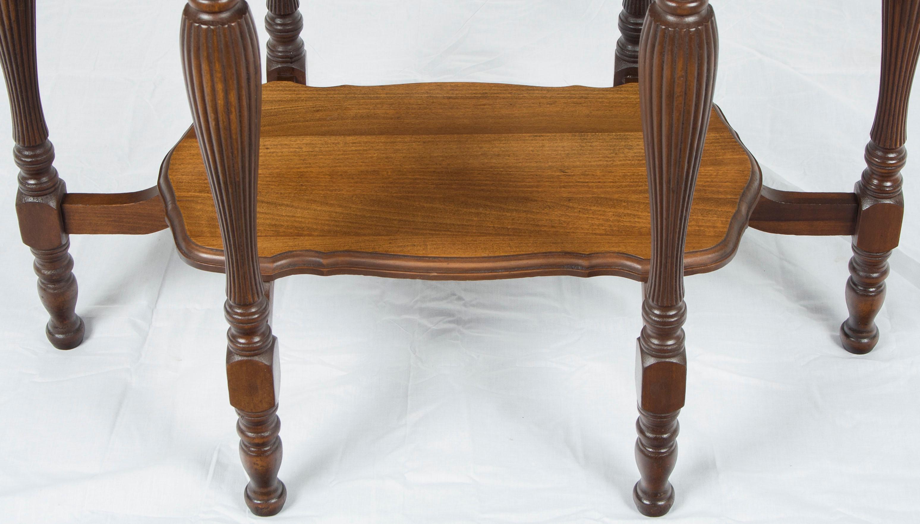 Perfect for a variety of uses, this mahogany shaped top side table is quite handsome. Six fluted and turned legs are complimented by a fluted decoration on the apron. A similarly shaped lower tier adds functionality and stability to the table as