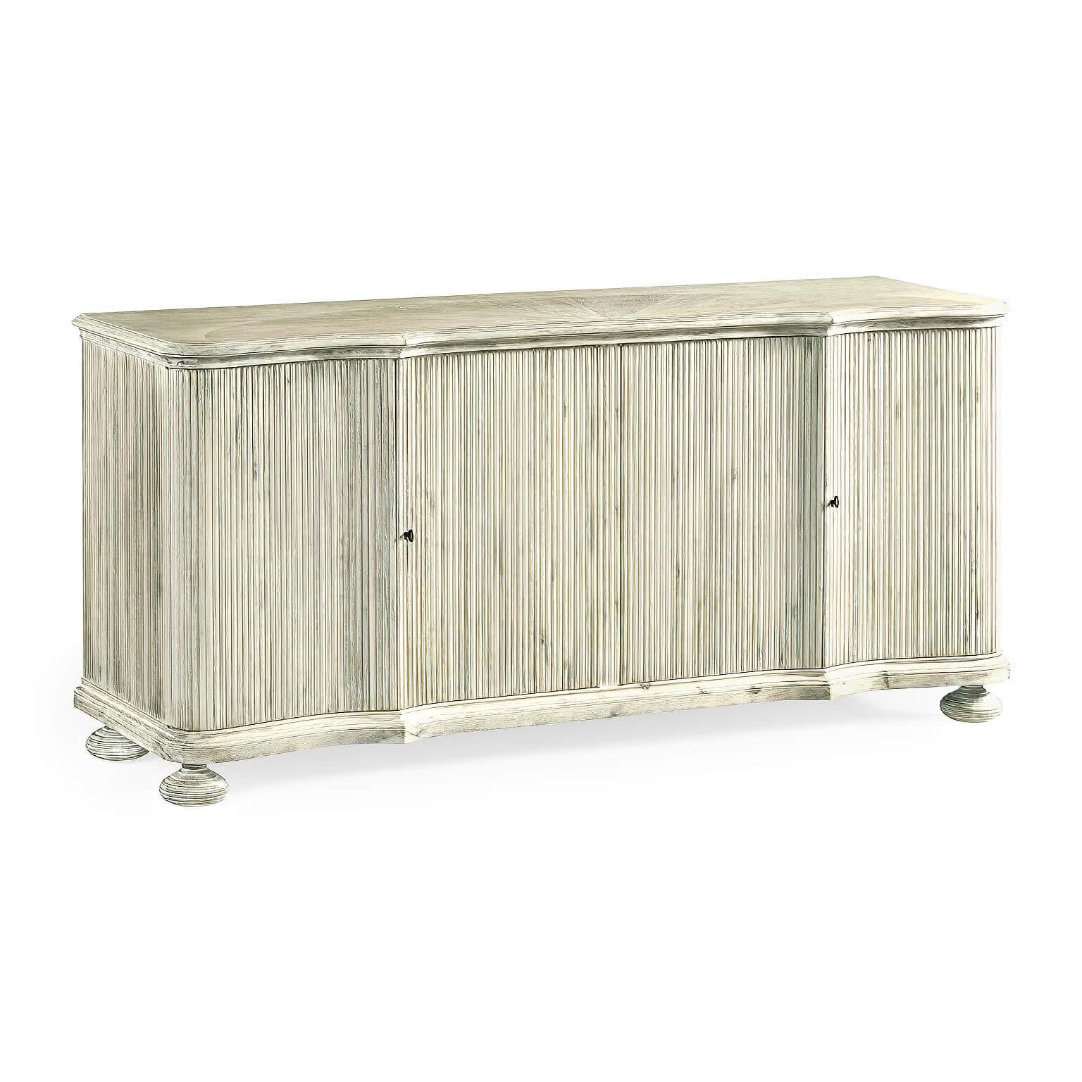 A modern whitewashed acacia buffet cabinet with reeded sides, a molded edge top, painted interior with adjustable shelves, and raised on bun feet.

Dimensions: 72.5