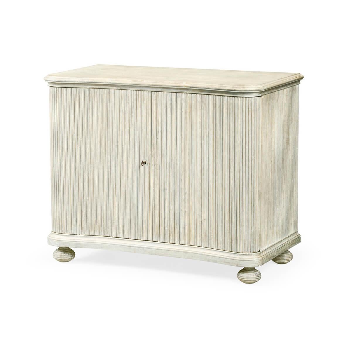 A modern white washed acacia cabinet with reeded sides, a molded edge top, painted interior with adjustable shelves and raised on bun feet.

Dimensions: 42