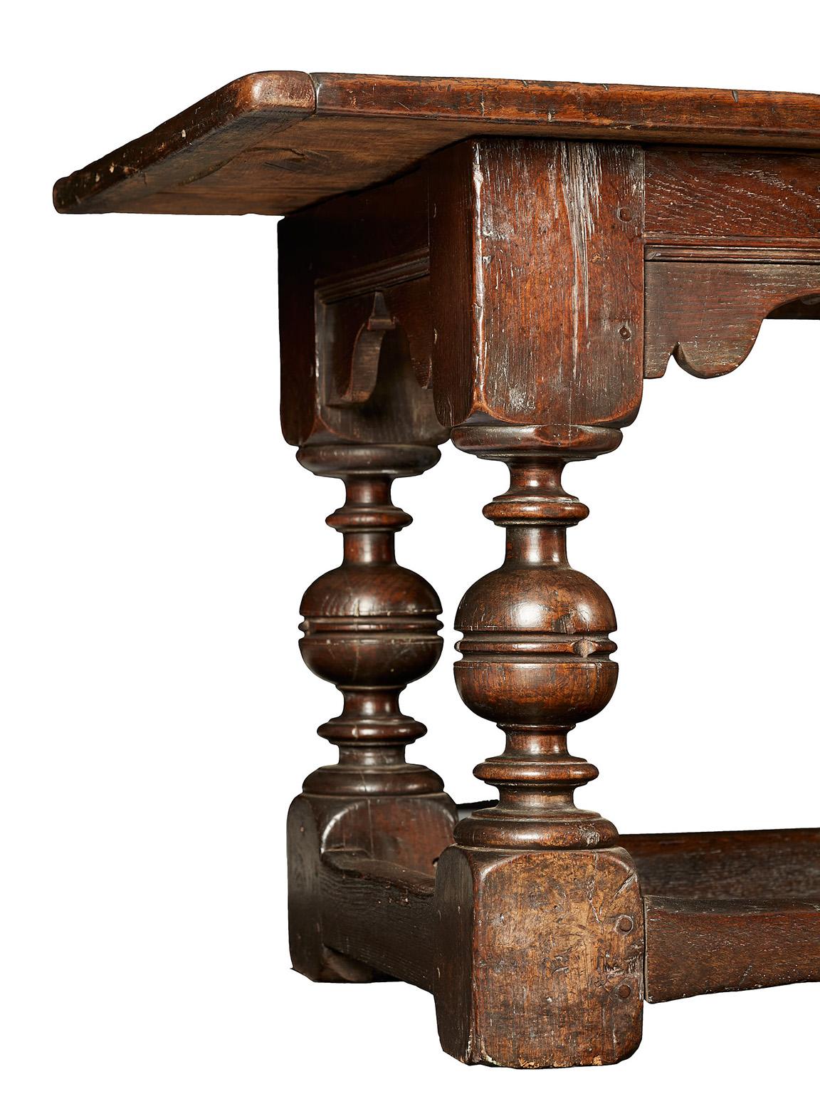 James I/Charles I oak refectory table dining table, Barnard castle, Northumbria, circa 1610-1640.

The four plank cleated top above moulded frieze rails with original spandrels, joined by
four bold cup and cover turned legs with plain stretchers.