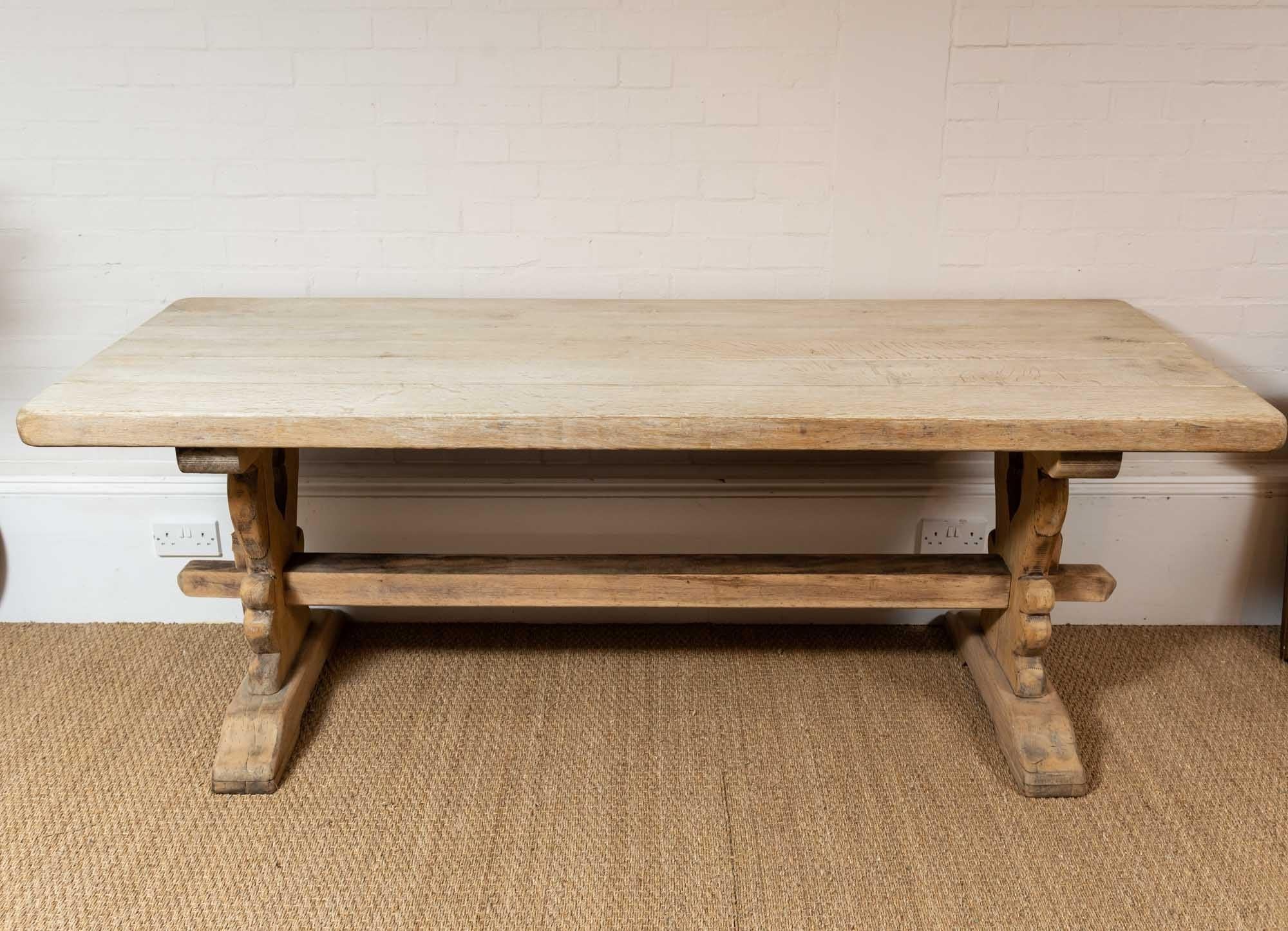 Perfect for a country kitchen this 1920s French refectory table has an earlier look and feel to it. Made from Oak it has a deep-planked top and central stretcher between the two legs making it a very comfortable table to sit at and perfect for a