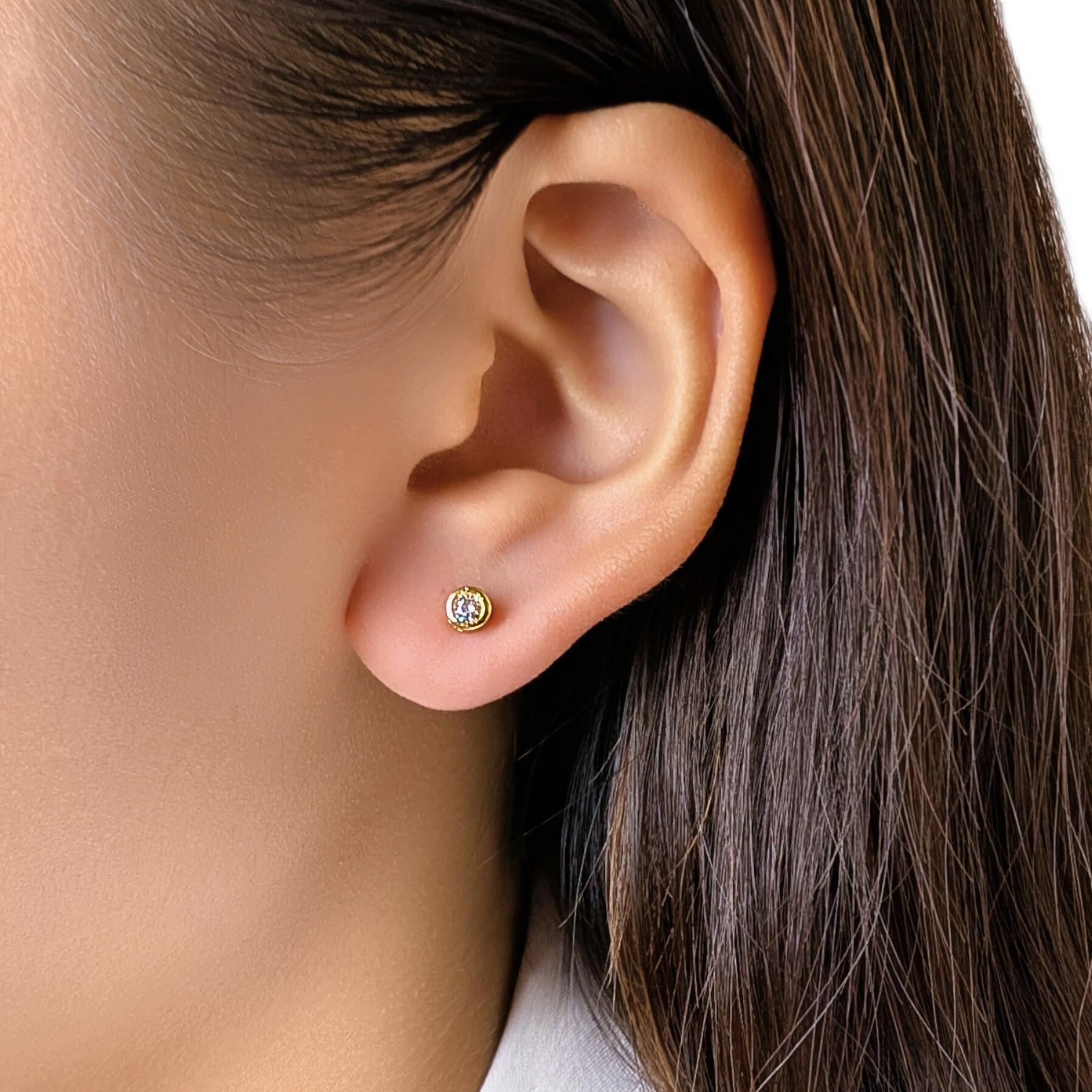 Questi eleganti orecchini con perno presentano 2 diamanti tondi brillanti (0,10ct in totale), di colore G-H e purezza VS, incastonati in castoni lisci in oro giallo 18K che ne esaltano il fuoco e la simmetria. Con un peso di 1,25 g, questo paio di