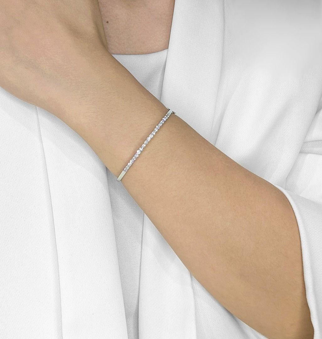 Timeless elegance meets modern sophistication in this 18K white gold bangle, adorned with 20 natural diamonds totaling 0.7 carats. Each round brilliant-cut diamond is meticulously placed to create a seamless sparkle, catching the light with every