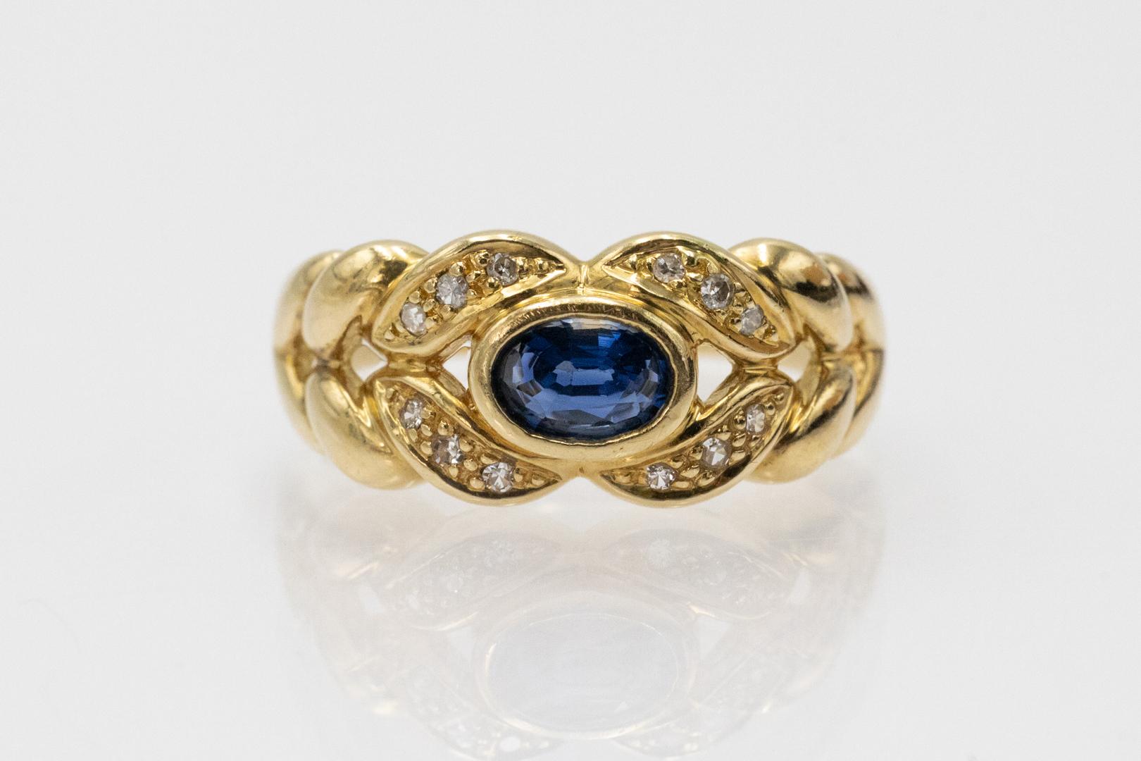 Un anillo único fabricado en oro amarillo de 18 quilates (ley 0,750). El anillo de oro está engastado con un zafiro natural central ovalado de aproximadamente 0,60 quilates y 12 diamantes talla 8/8 que suman aproximadamente 0,07 quilates (color E-F,