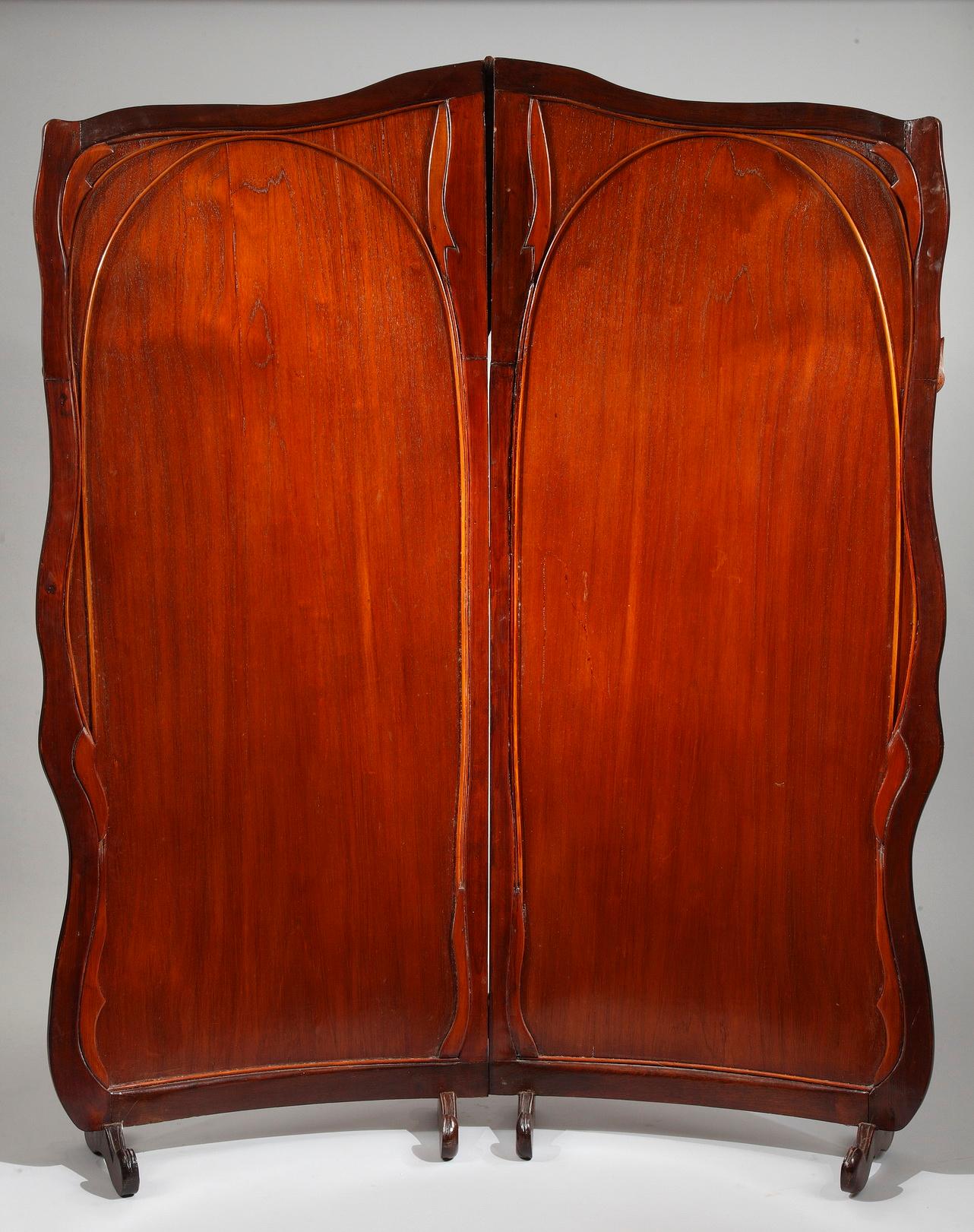 Rare screen composed of two scrolled panels resting on four foot pads.
The rich ornamentation represents wood marquetry aquatic flora, with applied water leaves.
A brass monogram is embedded in the wood marquetry, on the bottom right of the screen.