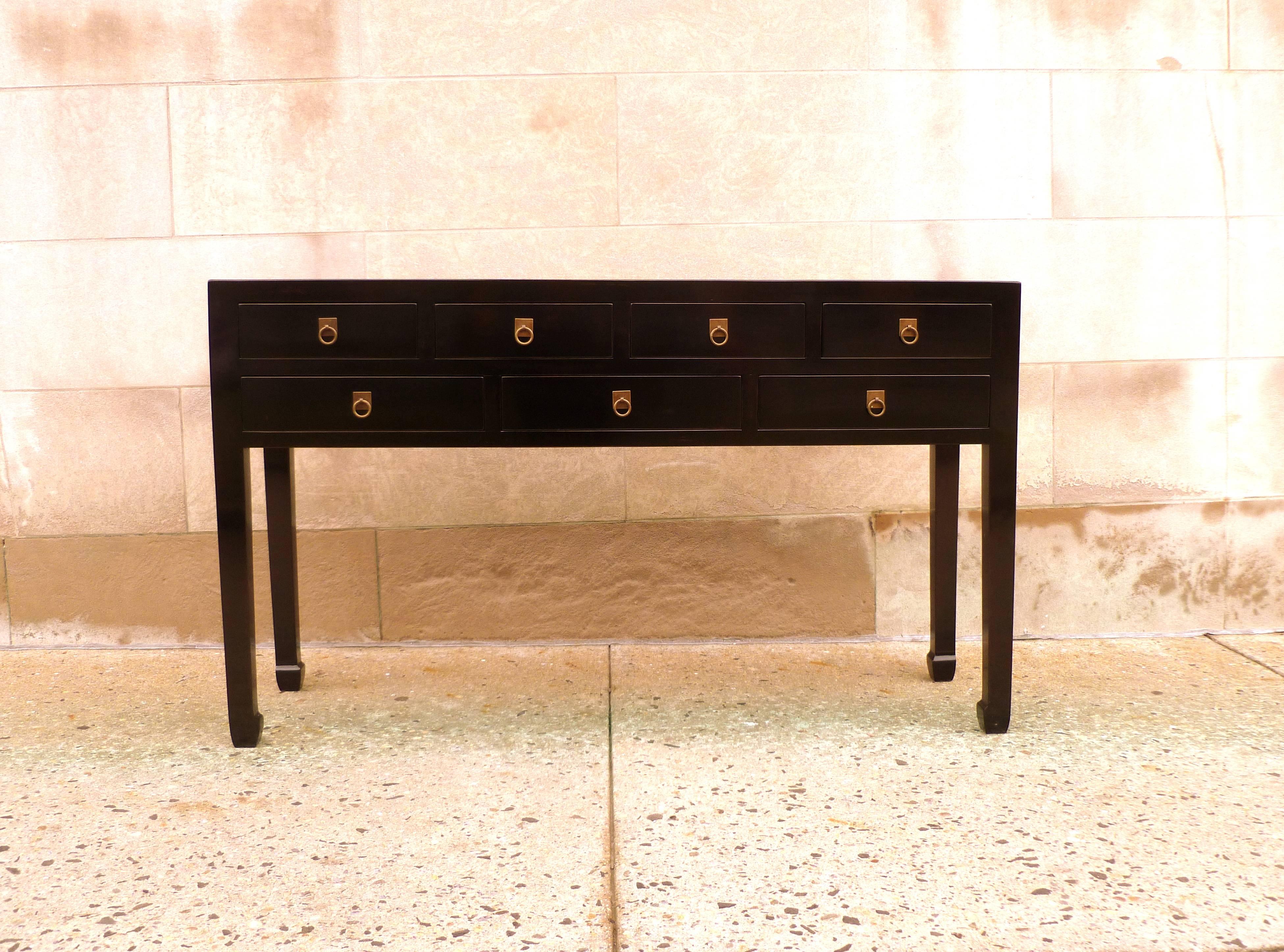 A simple and elegant black lacquer console table with seven drawers and brass ring pulls, beautiful color, form and lines. We carry fine quality furniture with elegant finished and has been appeared many times in 