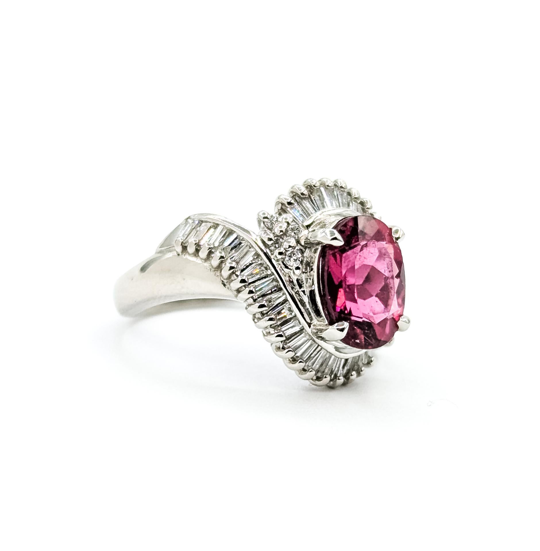 Cette bague exquise est réalisée en platine et met en valeur une tourmaline rose-rouge vibrante solidement sertie au centre dans un élégant design bypass. La tourmaline ovale pèse 1,85 carat, sa riche couleur étant magnifiquement complétée par un