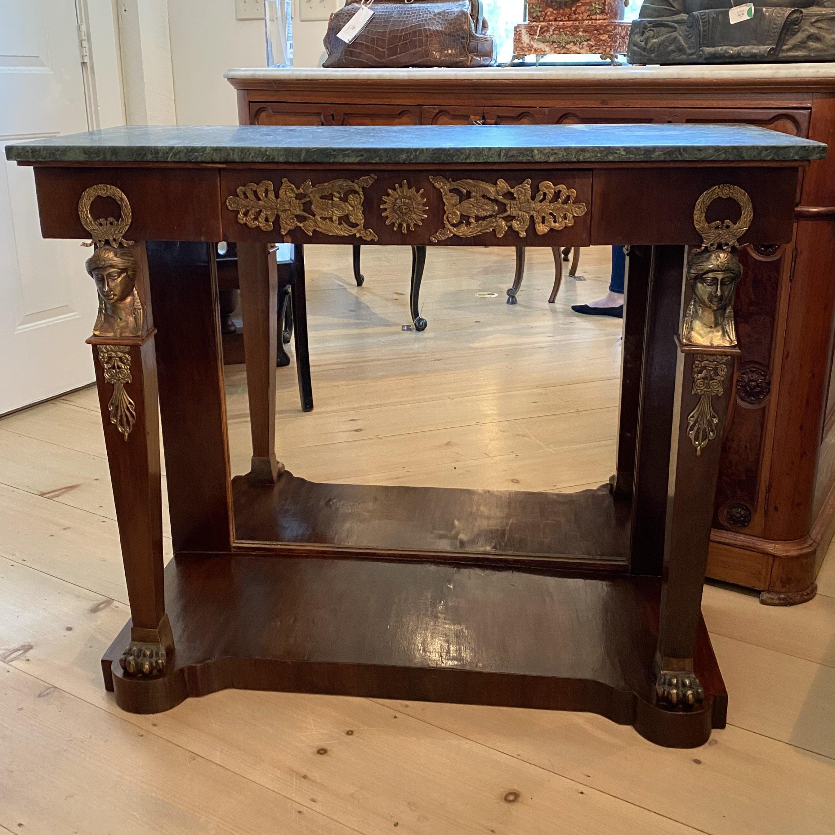 Fine French early 20th century mahogany neoclassical console or pier table having beautiful green marble top with molded edge over center drawer with bronze embellishments. The legs have bronze caryatids on top, ebonized tapering form and bronze