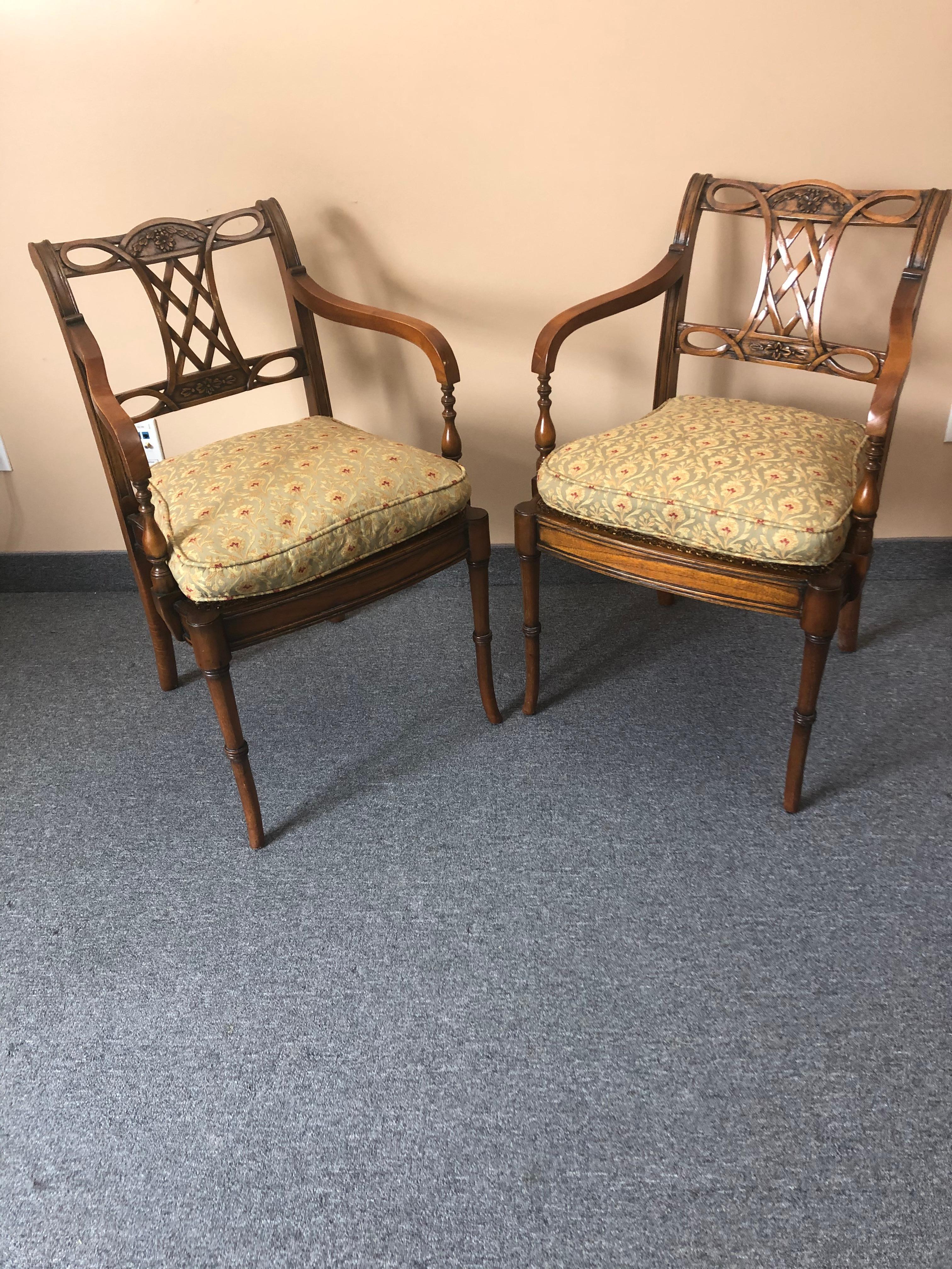 Refined pair of carved mahogany armchairs having beautiful details on the arms and legs and caned seats. Custom cushions are included.