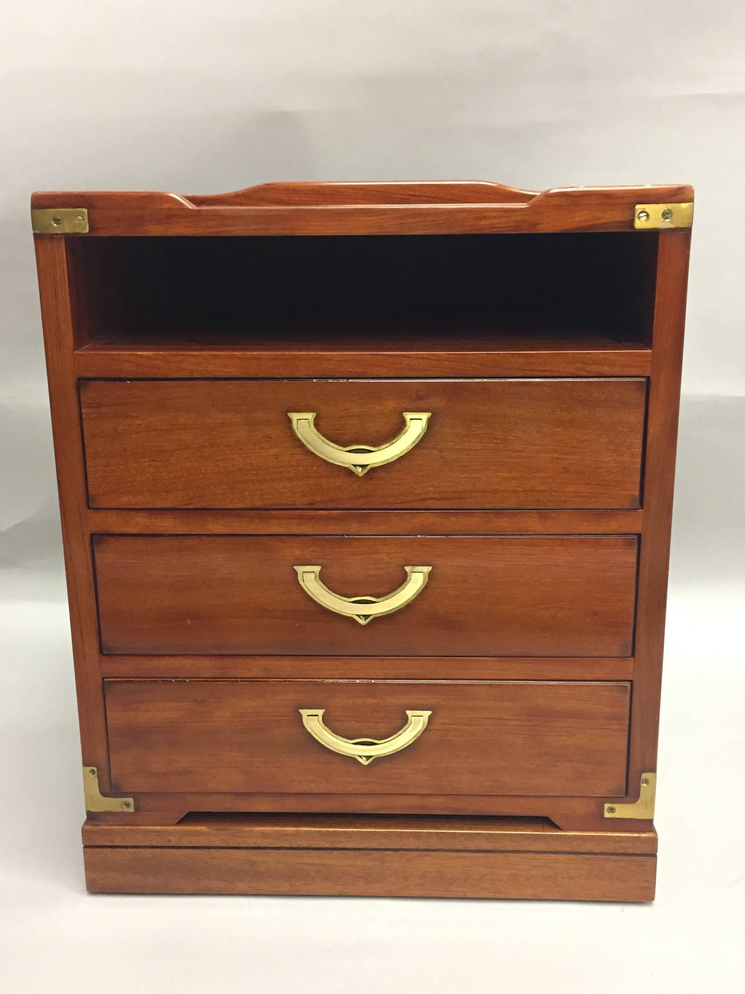 Two handsome mahogany and brass nightstands having three drawers and an open area under the top for storage that make them like little commodes. Original brass hardware and lovely dark inlay around the top. Created by Starbay, a company that