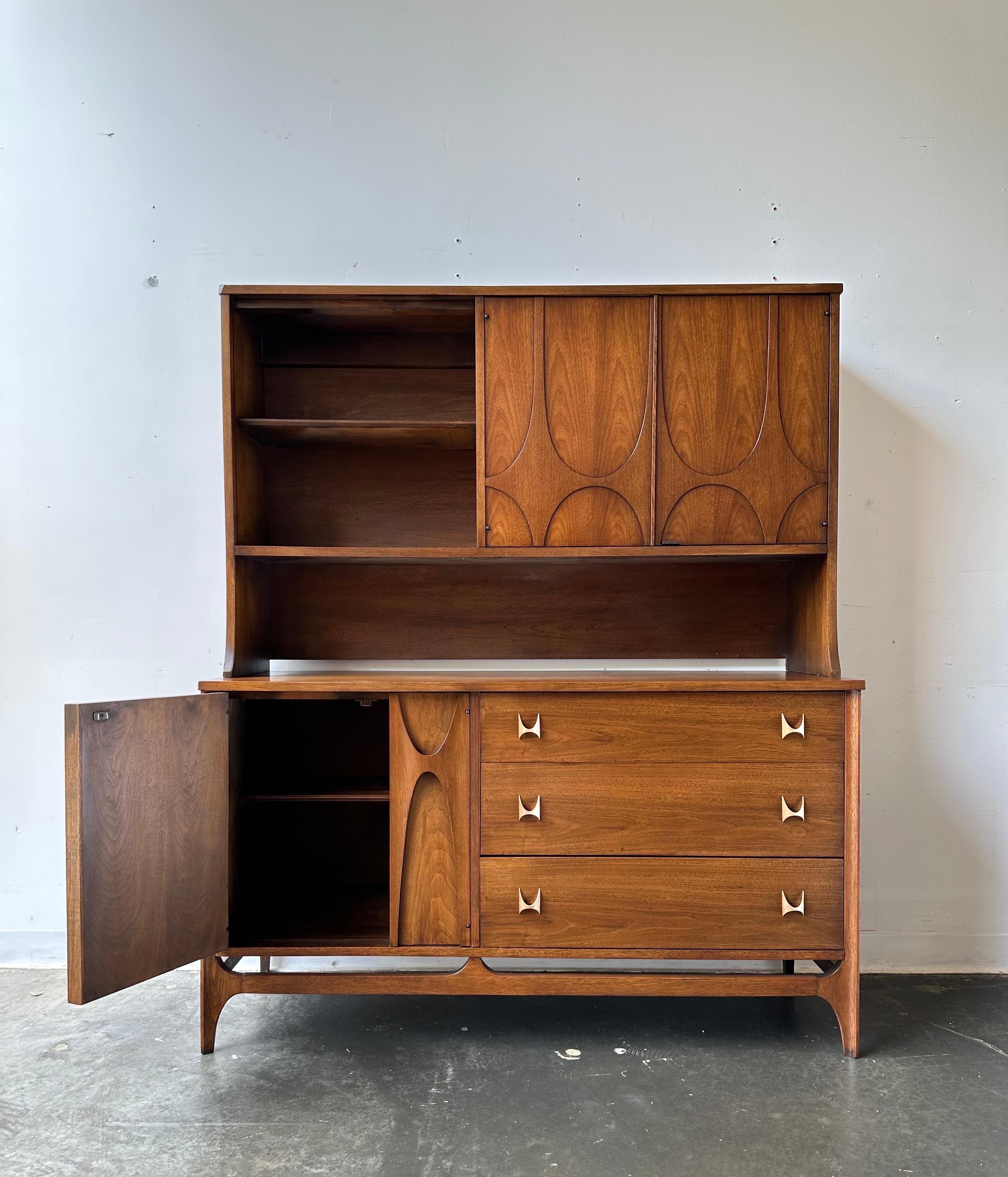Iconic Broyhill Brasilia credenza with hutch top.

Professionally refinished piece designed by Oscar neimeryer circa 1960.

Dim:

The buffet measures: 54 wide x 19 deep x 30 inches high
The hutch measures: 54 wide x 13.5 deep x 34 inches high
The