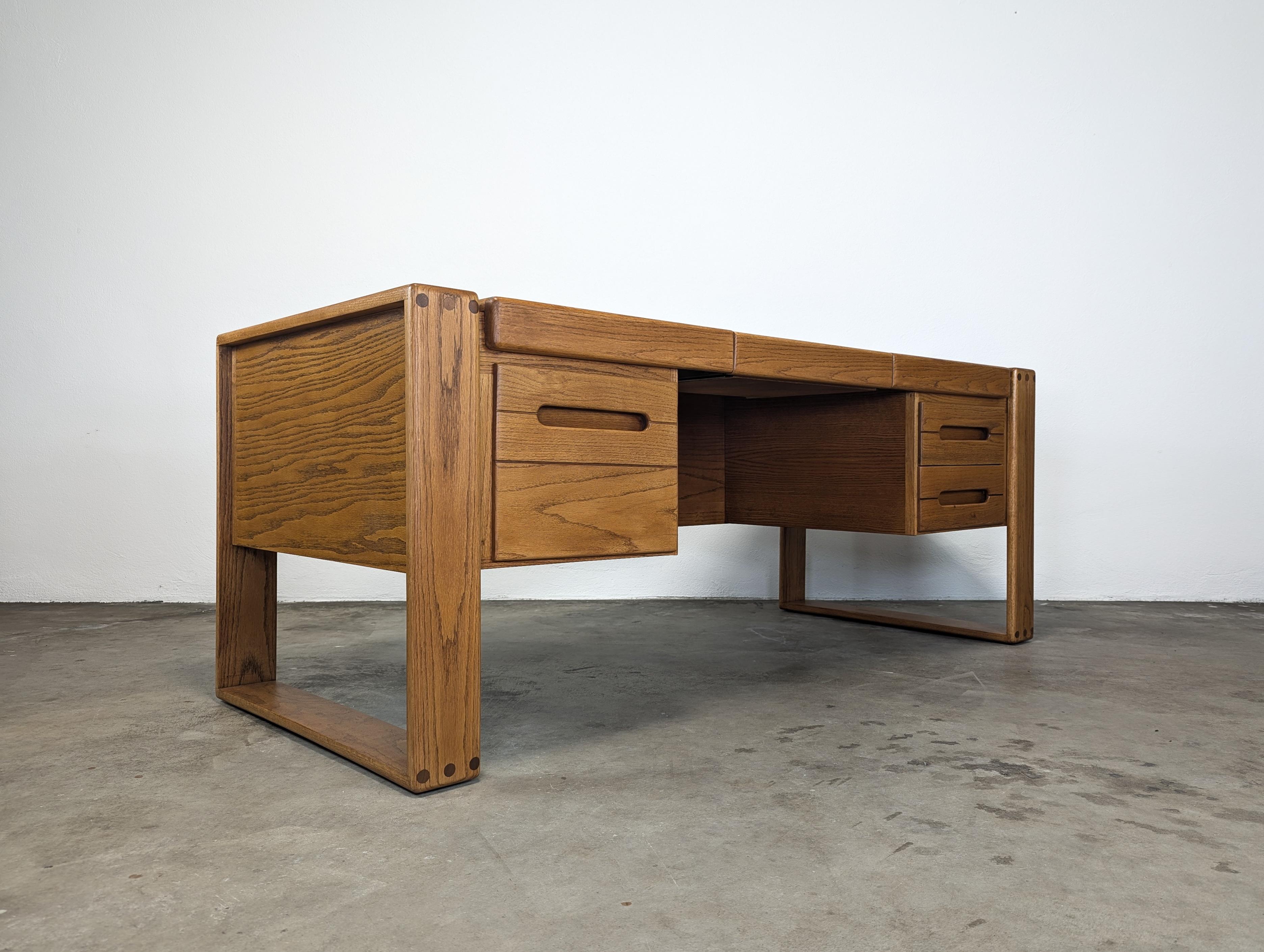 For sale is a stunning, professionally refinished desk designed by the iconic Lou Hodges for the California Design Group in 1981. This piece is a true testament to Hodges' unparalleled craftsmanship and keen sense of functional design.

The desk is