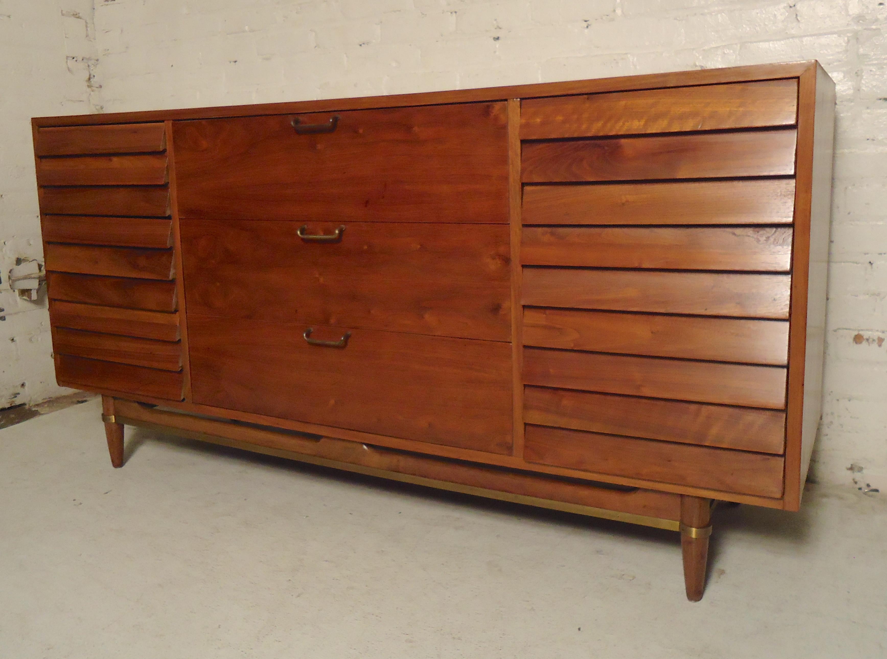 Vintage modern walnut dresser by American of Martinsville. Great style with louvered drawers and brass accents. Nine total drawers.
(Please confirm item location - NY or NJ - with dealer).
 