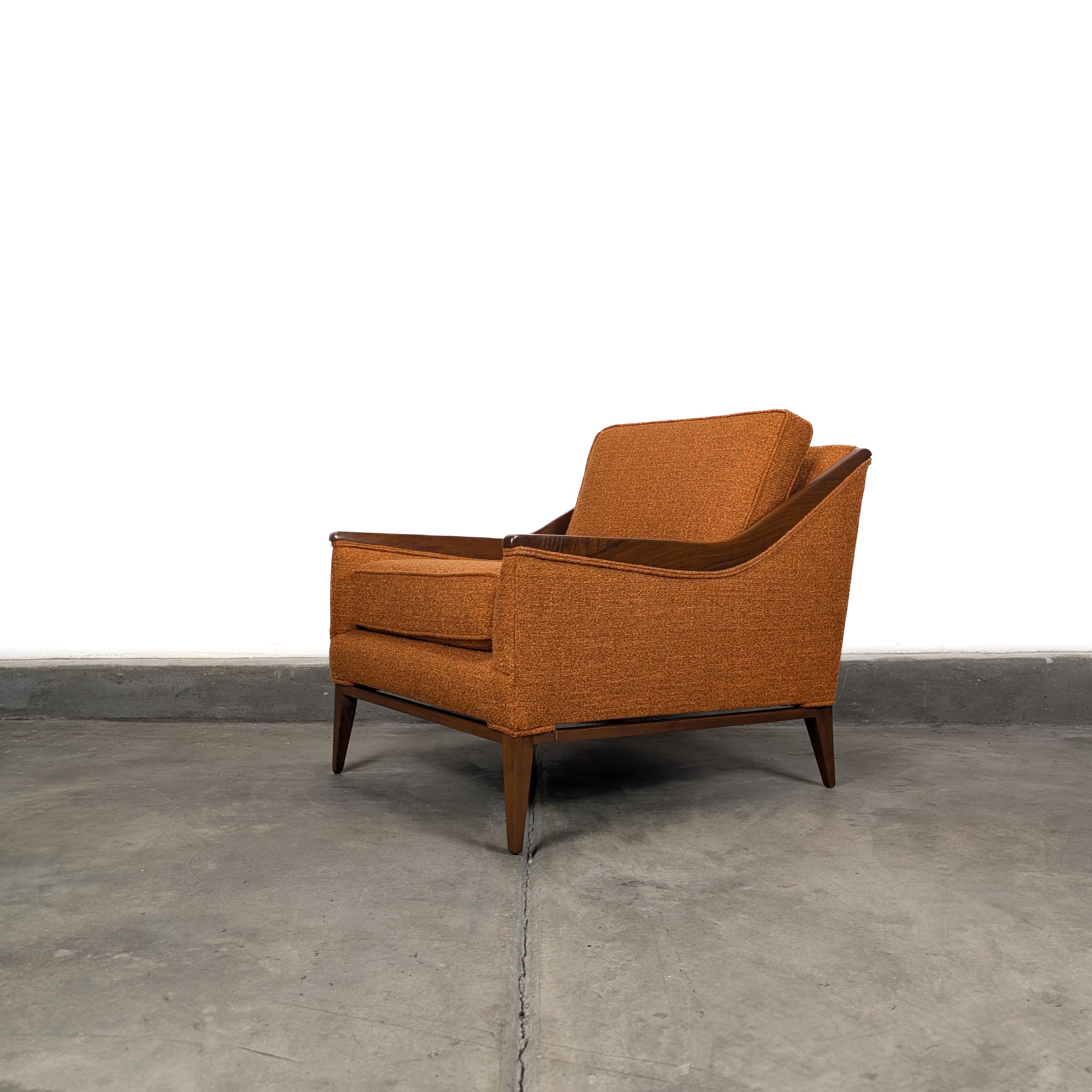 This vintage Mid-Century Modern armchair (c.1960s) is a striking piece that embodies the clean lines and timeless elegance of the era. Beautifully restored, it features newly refinished walnut trim paired with fresh burnt orange upholstery that adds