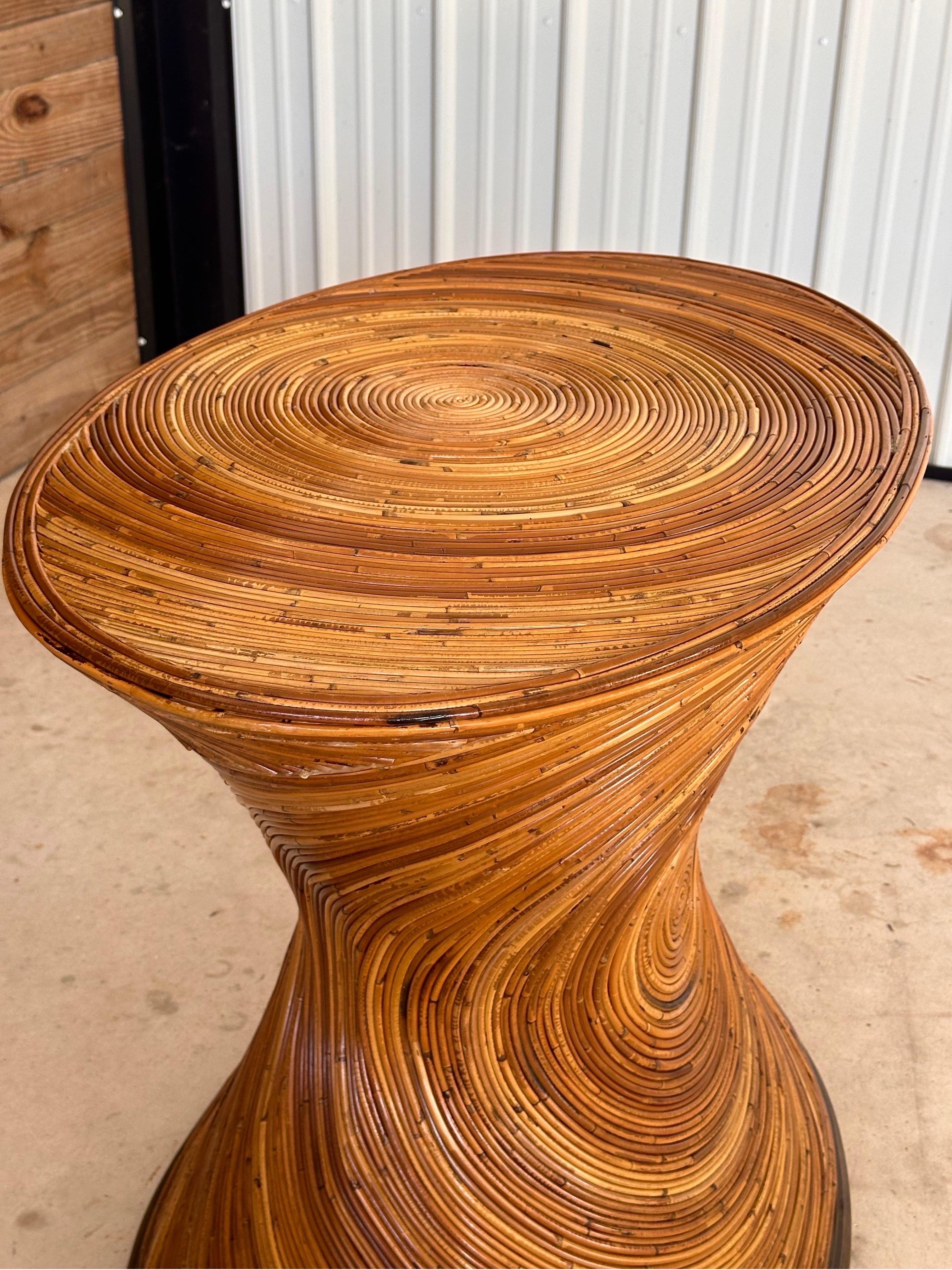 Elevate your interior with this striking Refinished 1960s Pencil Reed Rattan hourglass dining table base. Its distinctive hourglass shape and meticulously crafted concentric reed pattern make it a standout piece, perfect for adding a touch of