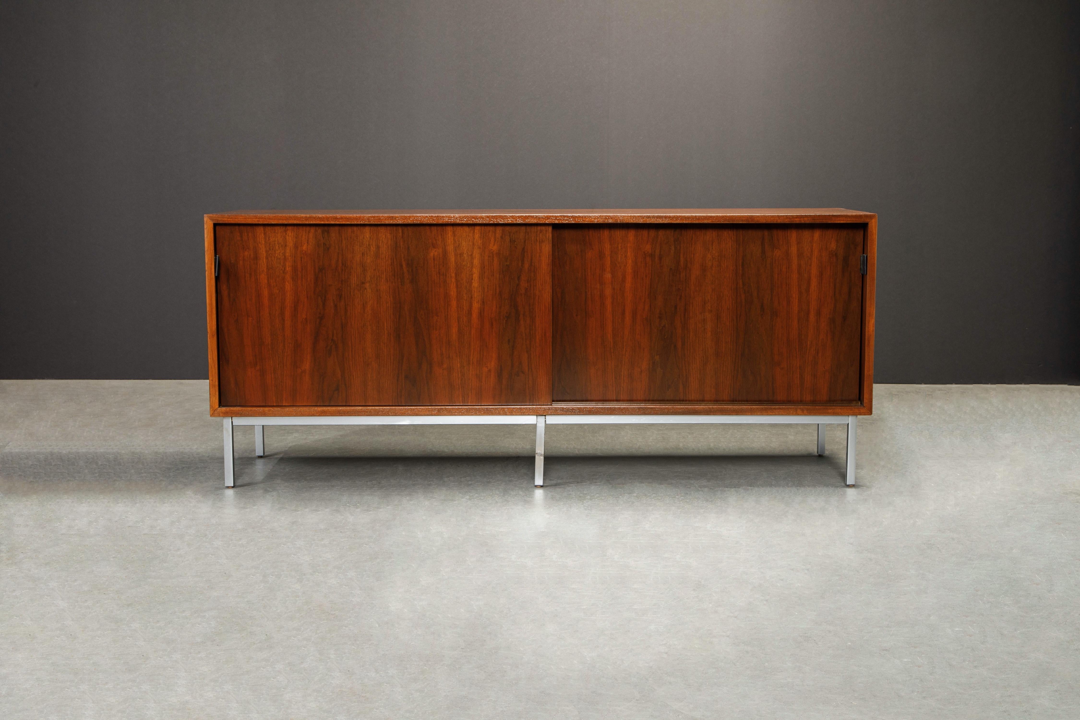 Sleekly designed credenza by Florence Knoll for Knoll Studio signed with Knoll Studio and Florence Knoll's signature on one leg. This newly restored sideboard credenza is fabricated from walnut and sits on top of a metal base with six legs.

The